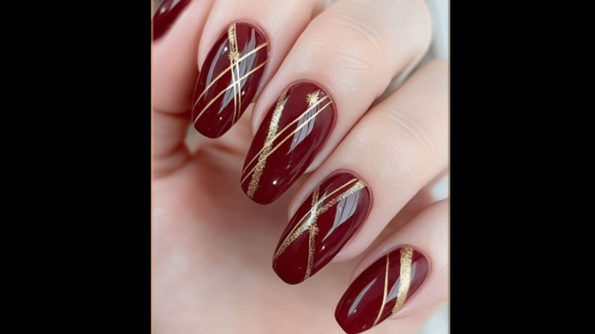 Deep red nails with gold line art