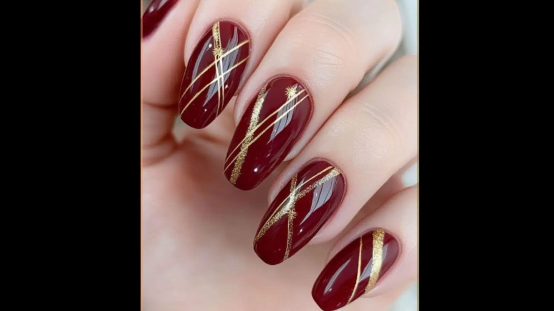 Deep red nails with gold line art