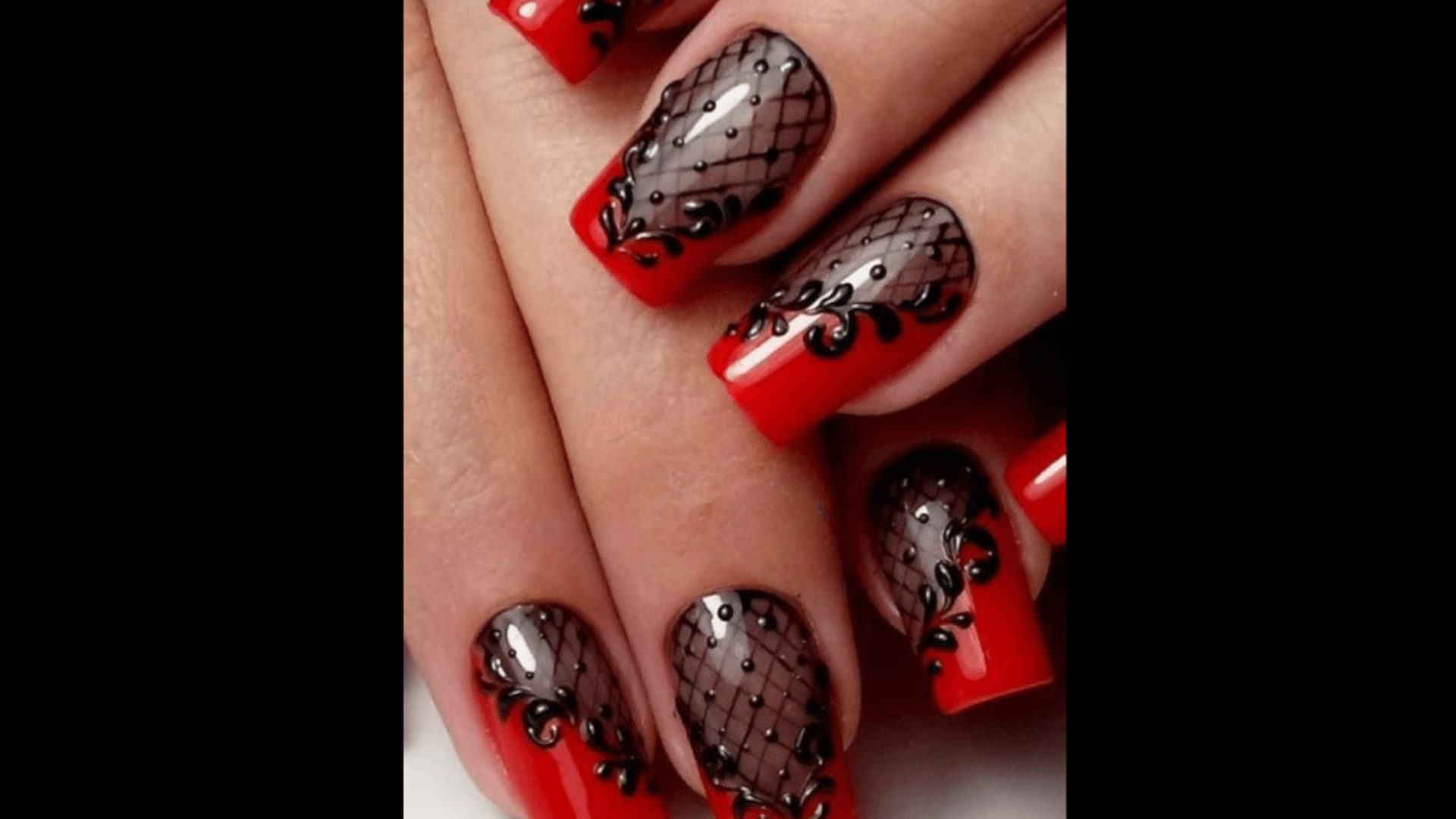 Red nails with black lace patterns