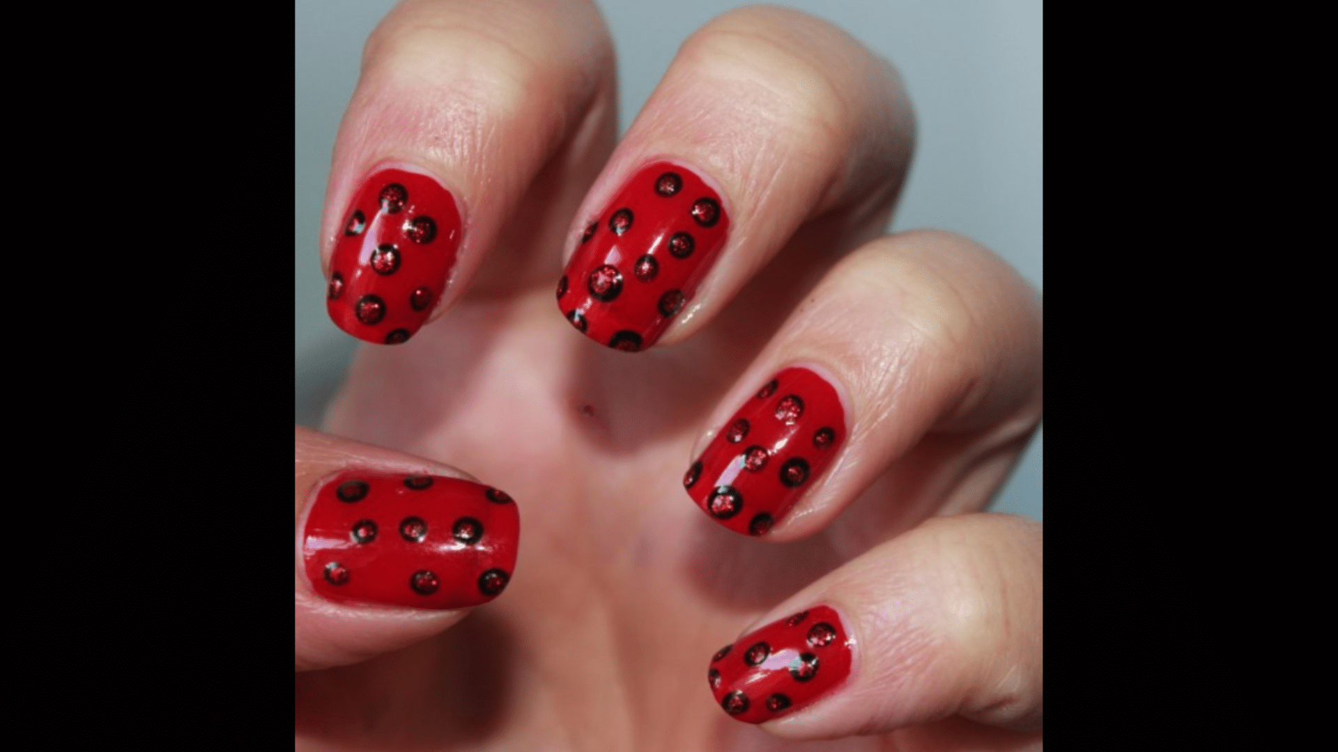 Red nails with black polka dots