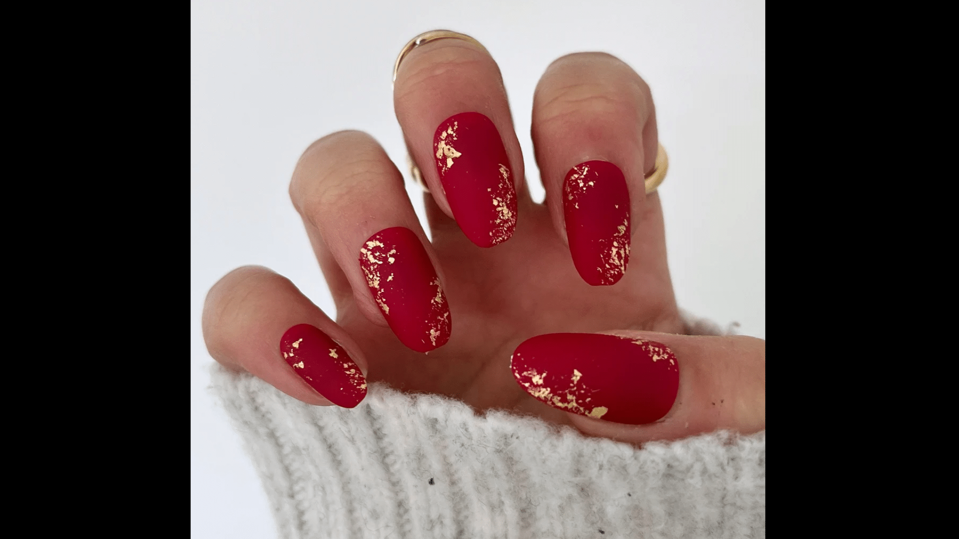Red nails with gold foil flakes