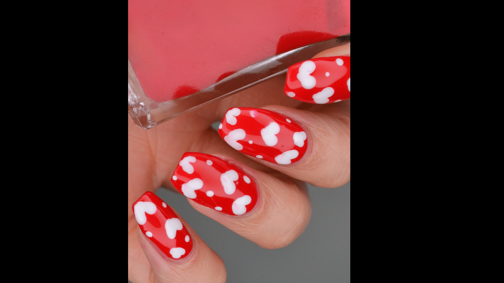 Red nails with tiny white dots and hearts