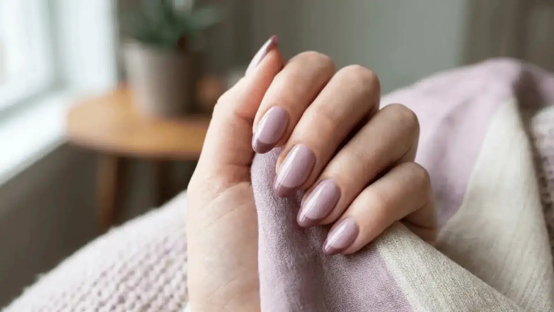 A soft mauve base paired with deeper mauve tips refreshes the classic French manicure on oval shapped nails