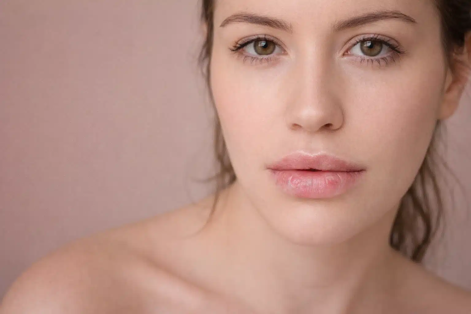 Close up of woman with natural lips showing soft color, representing lip blush healing results and importance of follow up care