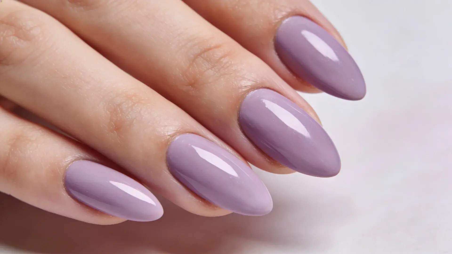 Glossy lavender purple almond shaped manicure close up showing smooth polished finish
