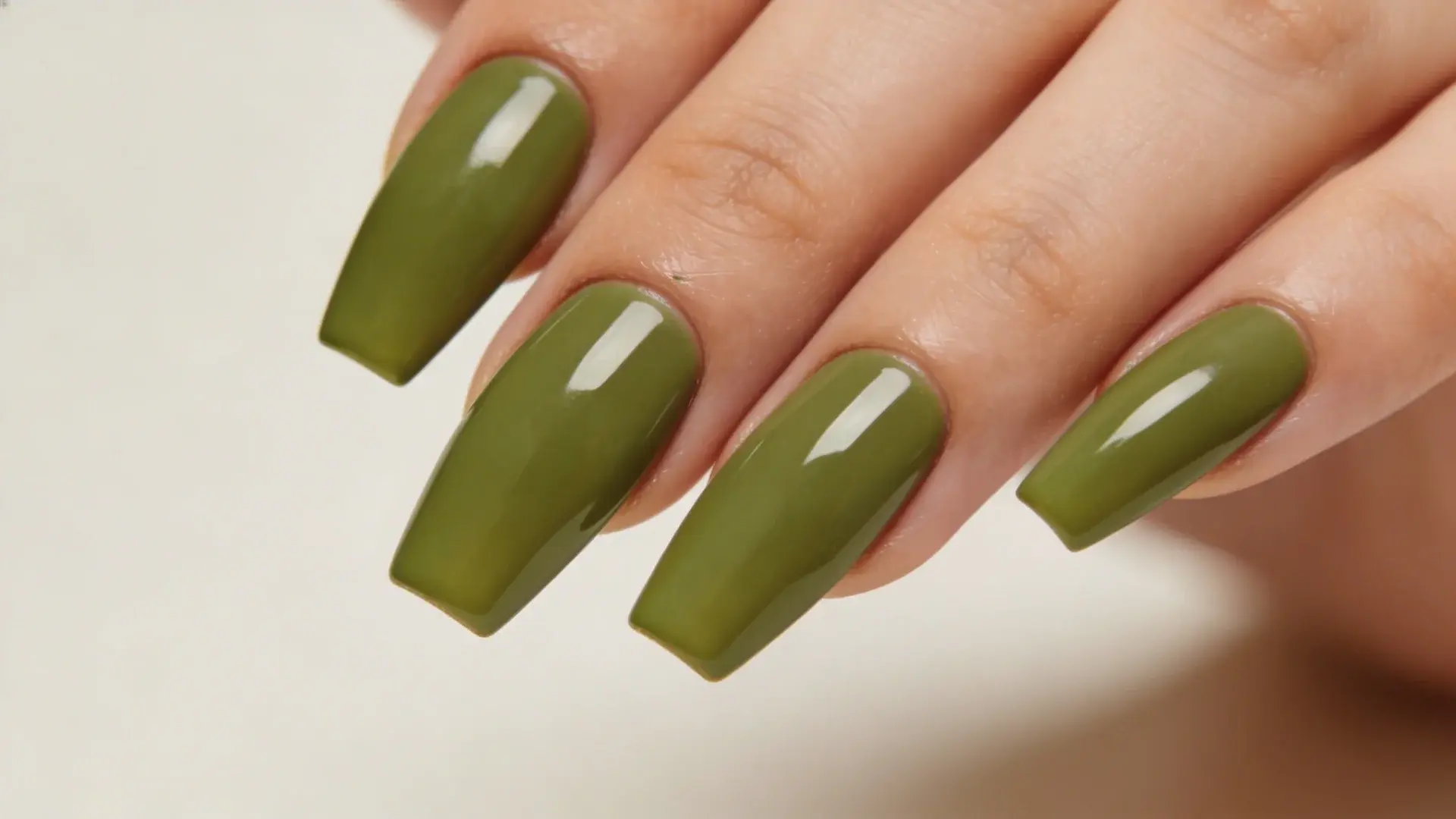 Olive green square shaped manicure with glossy finish close up on hand