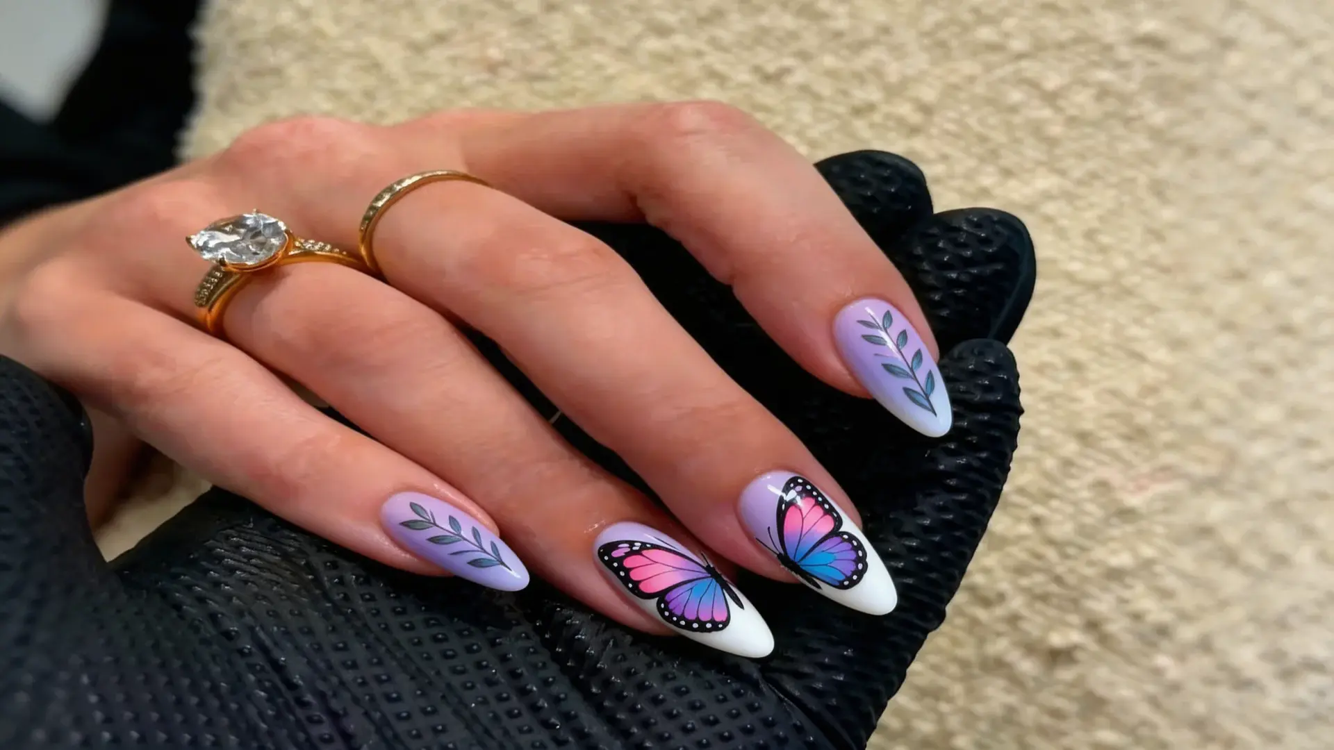 Pastel purple and white butterfly accent nail art with leaves on almond shaped nails showing spring nails inspiration