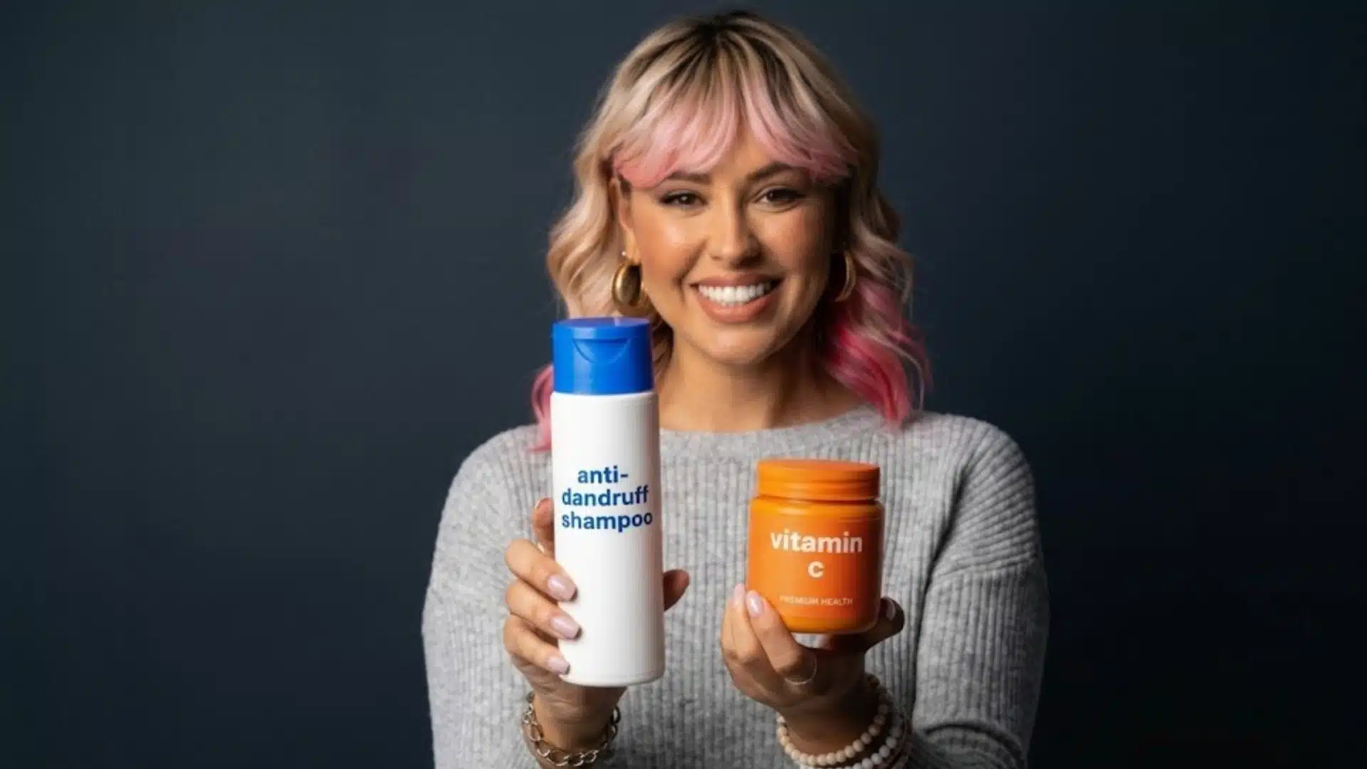 A smiling woman with pink-tipped blonde hair holds a white anti-dandruff shampoo bottle and an orange vitamin C supplement jar