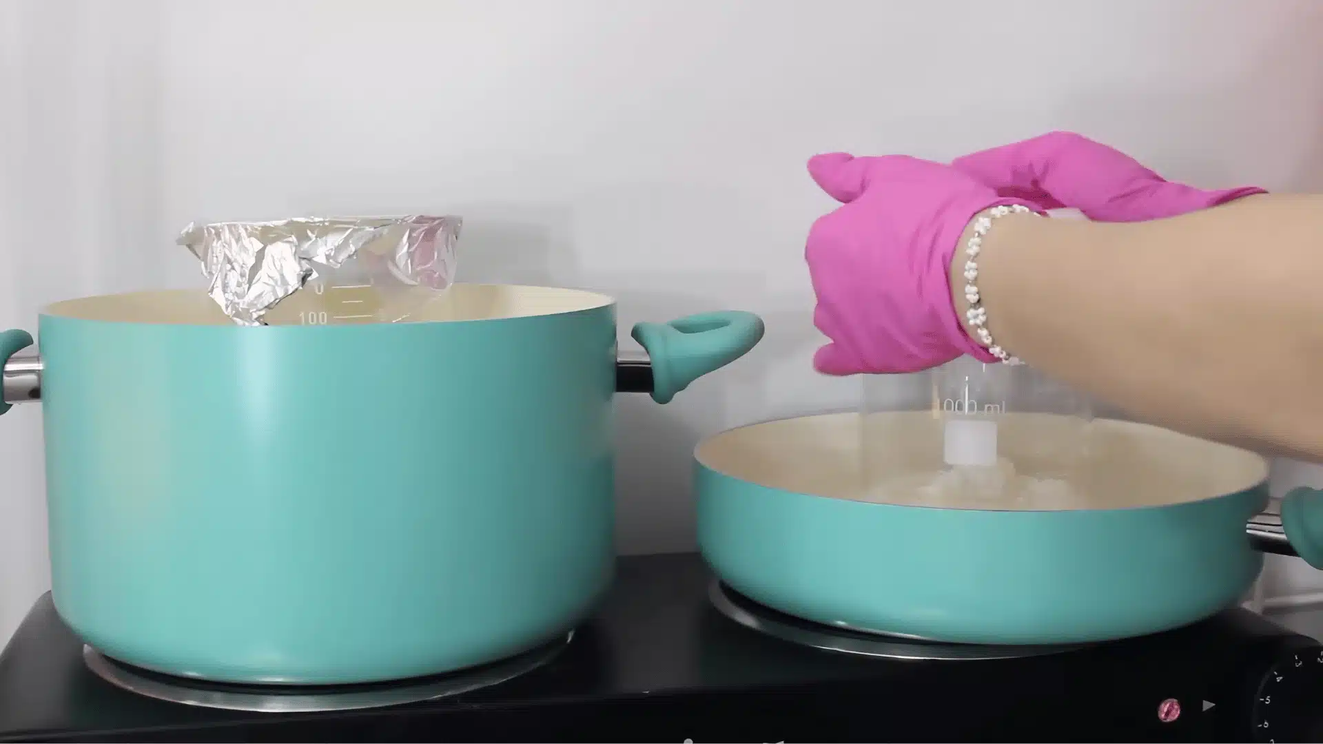 DIY lotion ingredients heated in a double boiler using pots and glass beaker setup