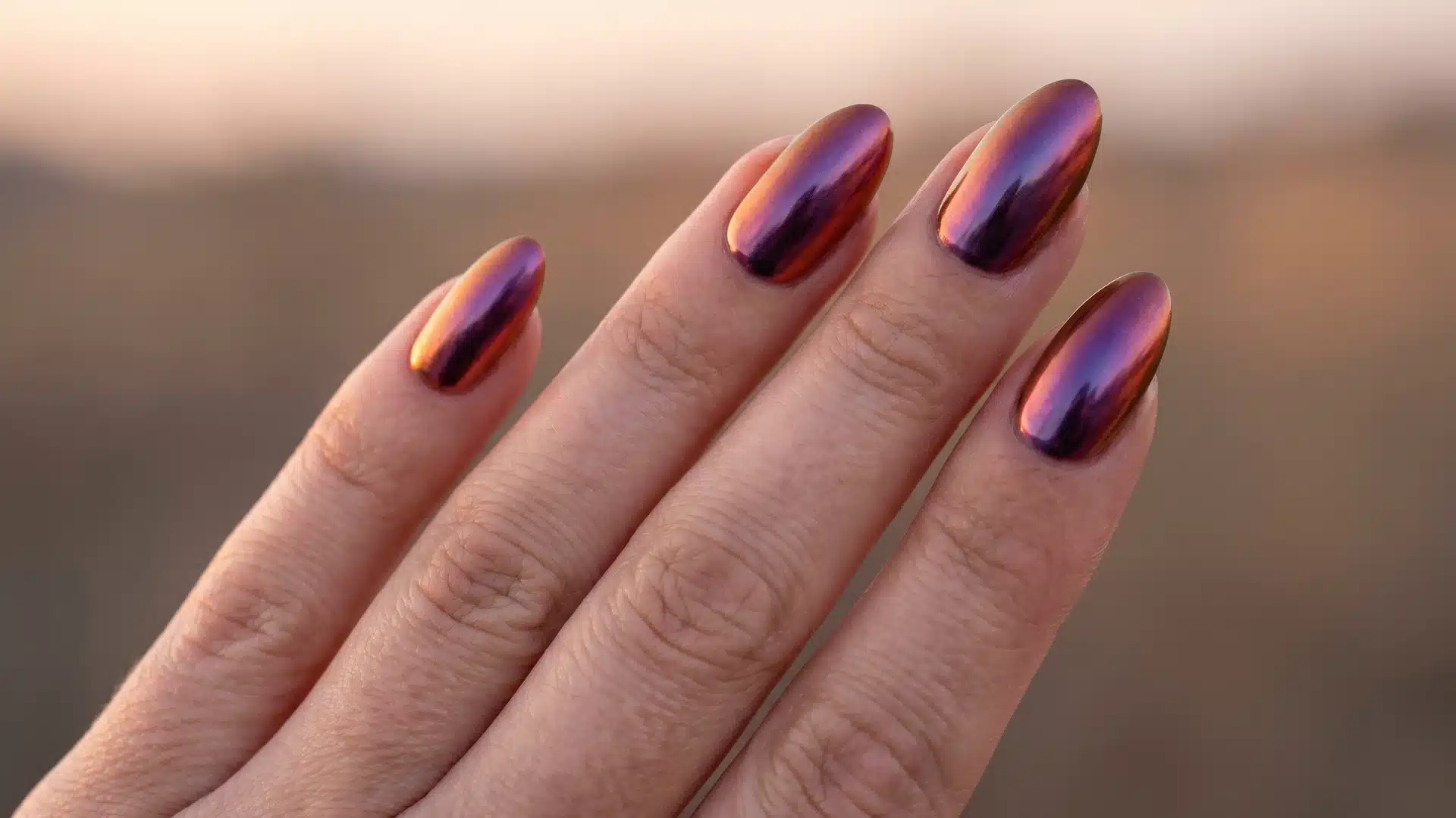 Duochrome chrome nails shifting copper to deep purple in sunset light