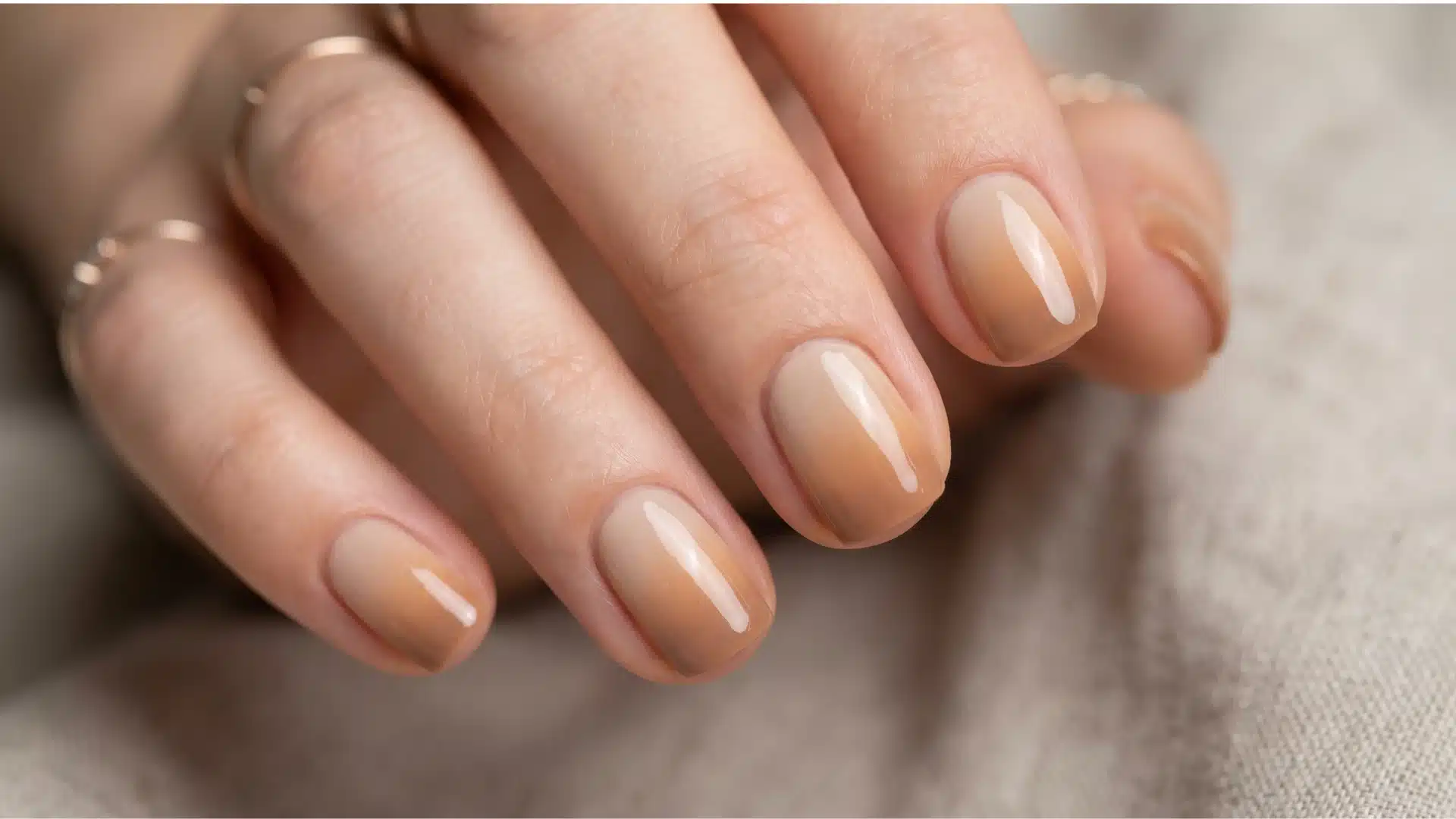 Glossy nude gradient nails with warm beige fade and soft natural finish (1)
