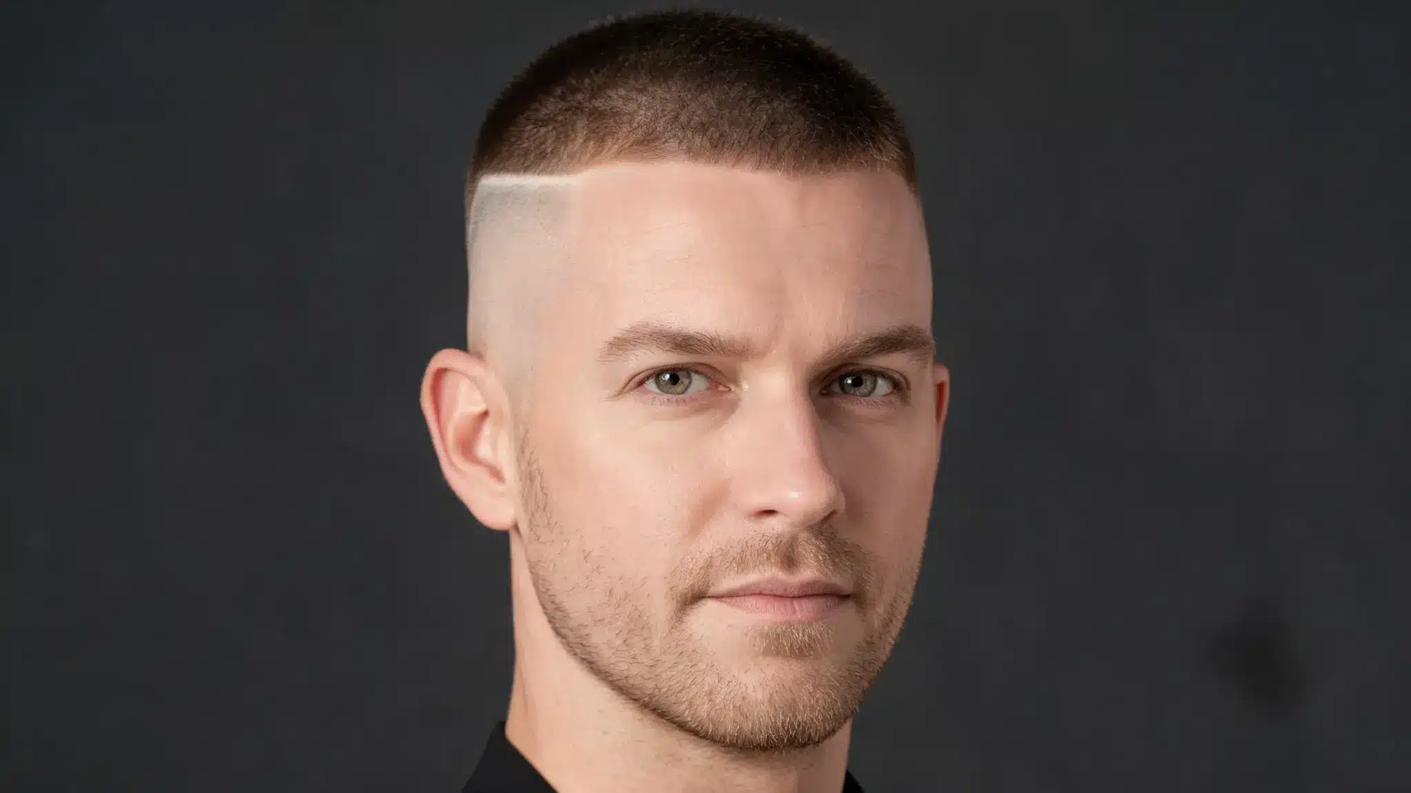 Man with a high and tight haircut, very short faded sides, short top, and light stubble
