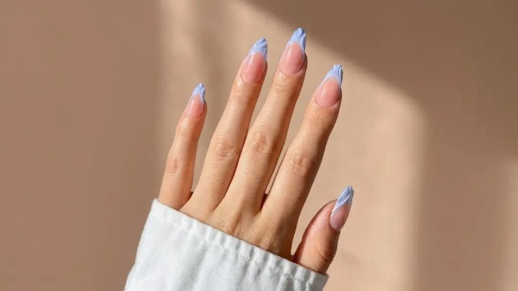 Almond nails with soft blue French tips on sheer pink base, clean glossy finish, minimal spring nail design