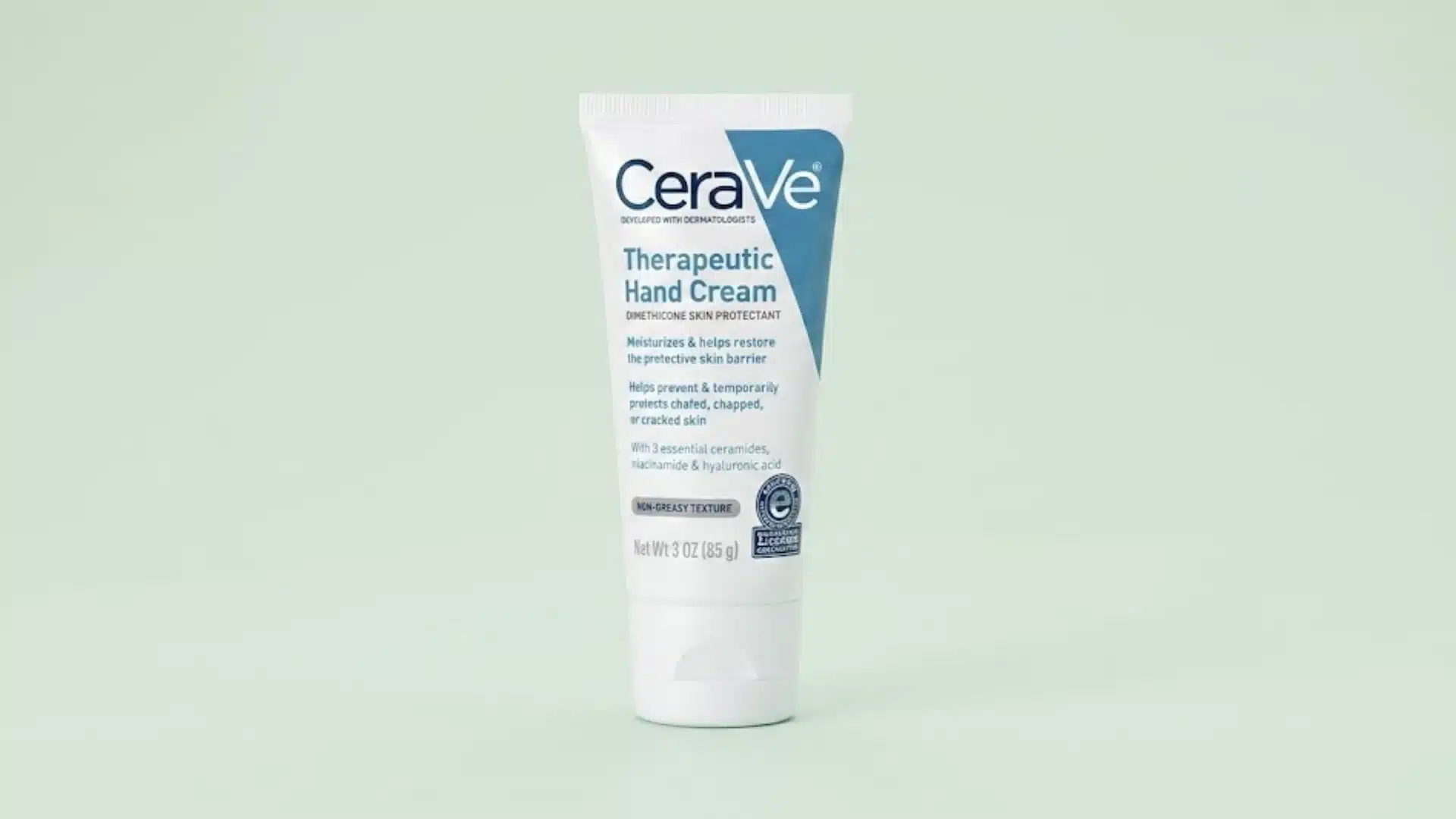 A tube of CeraVe Therapeutic Hand Cream centered against a solid, light pastel green background