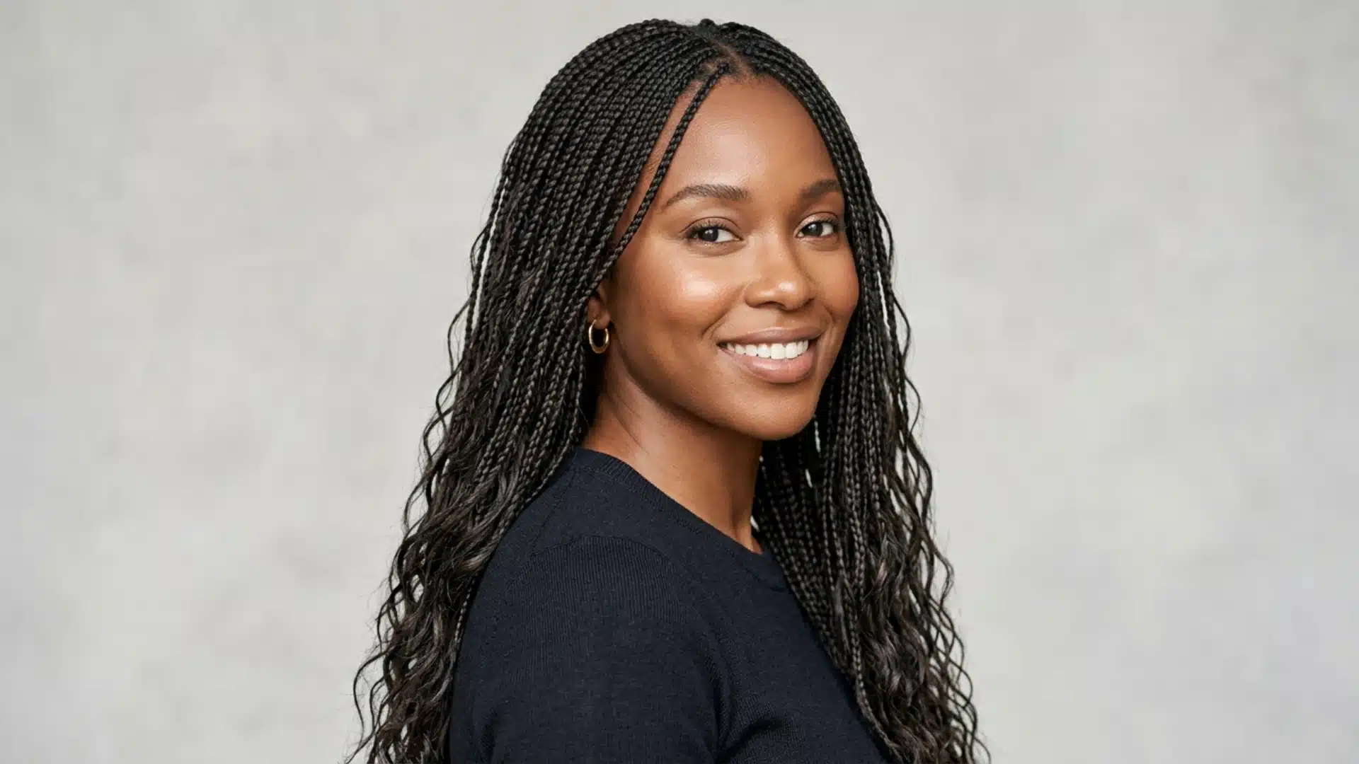 Black woman with long micro braids worn loose showing fine individual braid size and volume