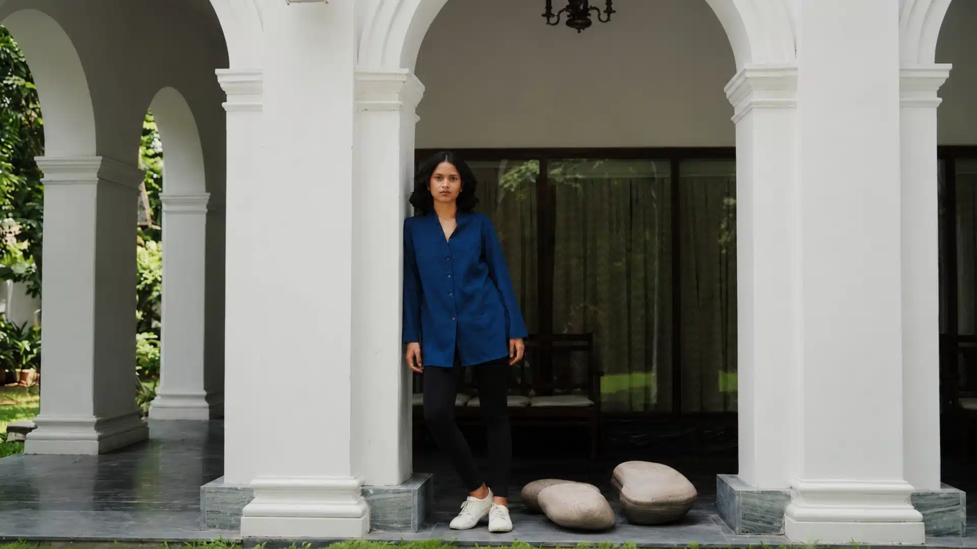 Blue button-down shirt with black leggings and white sneakers, classic casual look