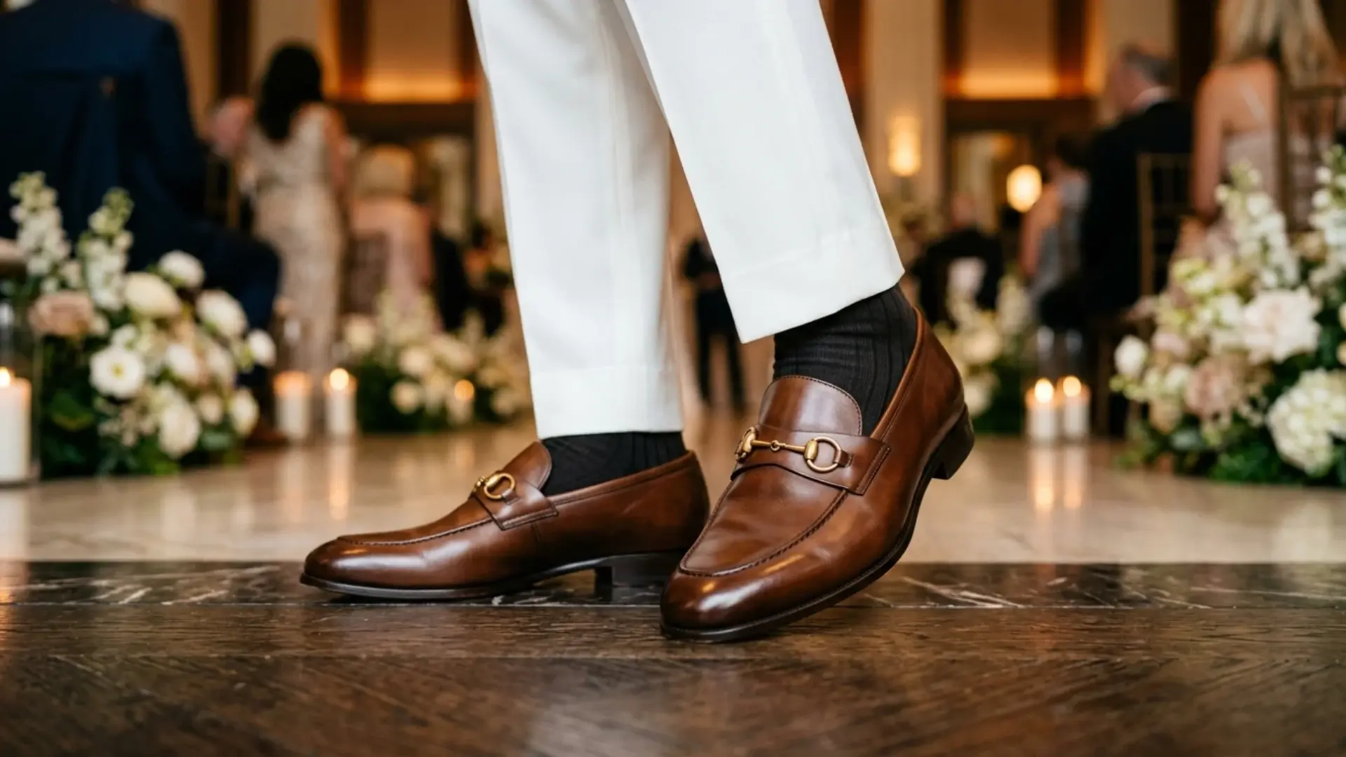 Brown horsebit loafers paired with white trousers at formal event refined luxury mens dress shoe style