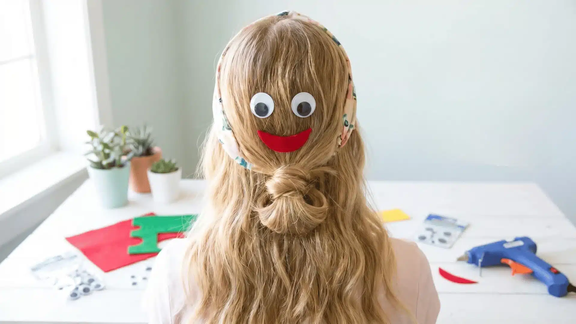 Child with face hairstyle using googly eyes and red smile