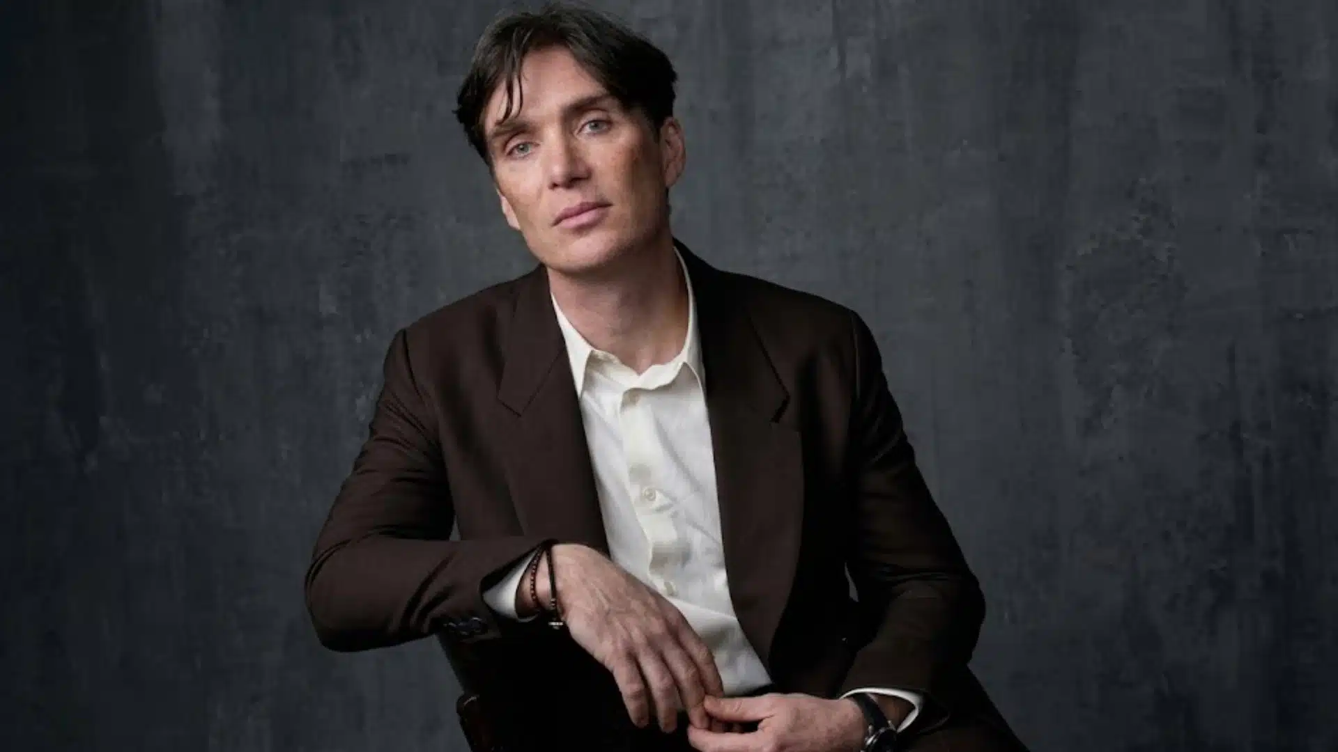 Cillian Murphy with cool toned features wearing dark brown suit and white shirt, showcasing soft contrast