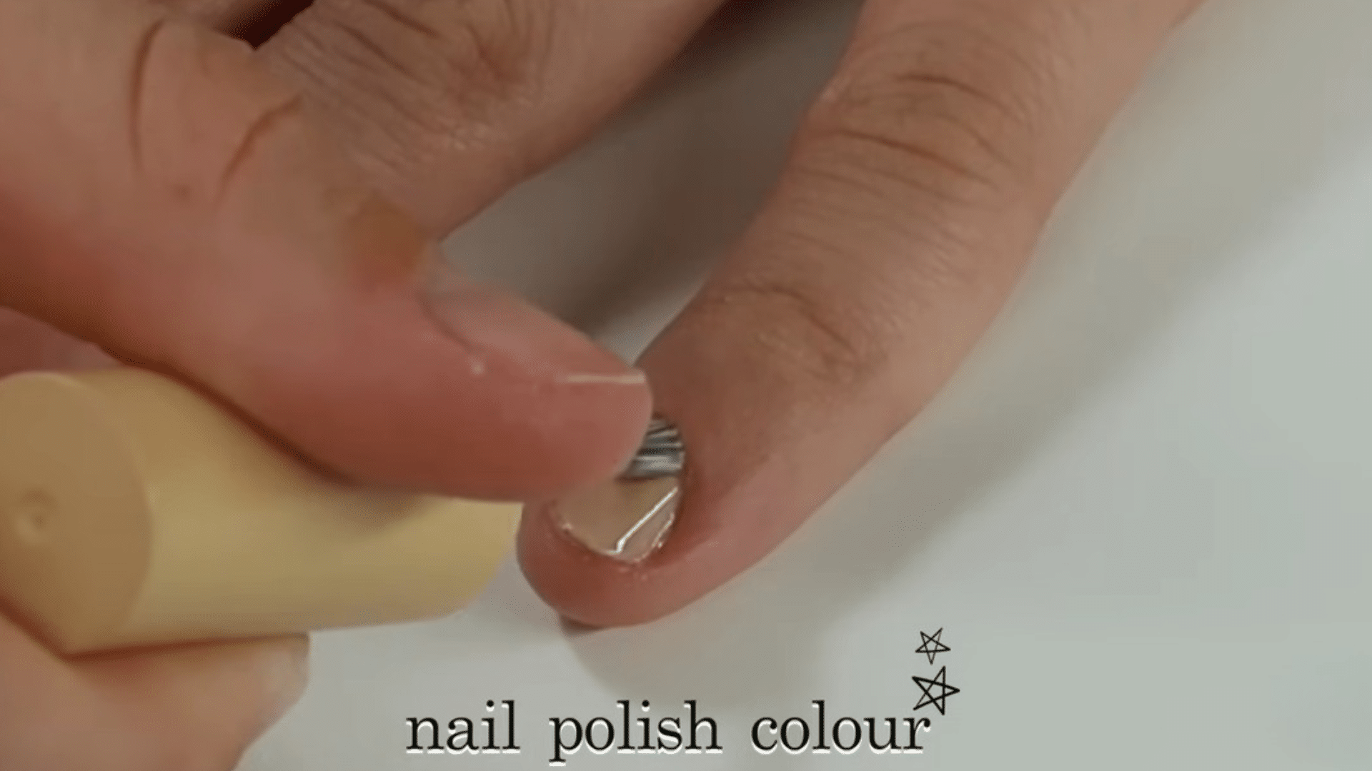 Close up of applying nail polish color on fingernail during at home manicure tutorial on YouTube
