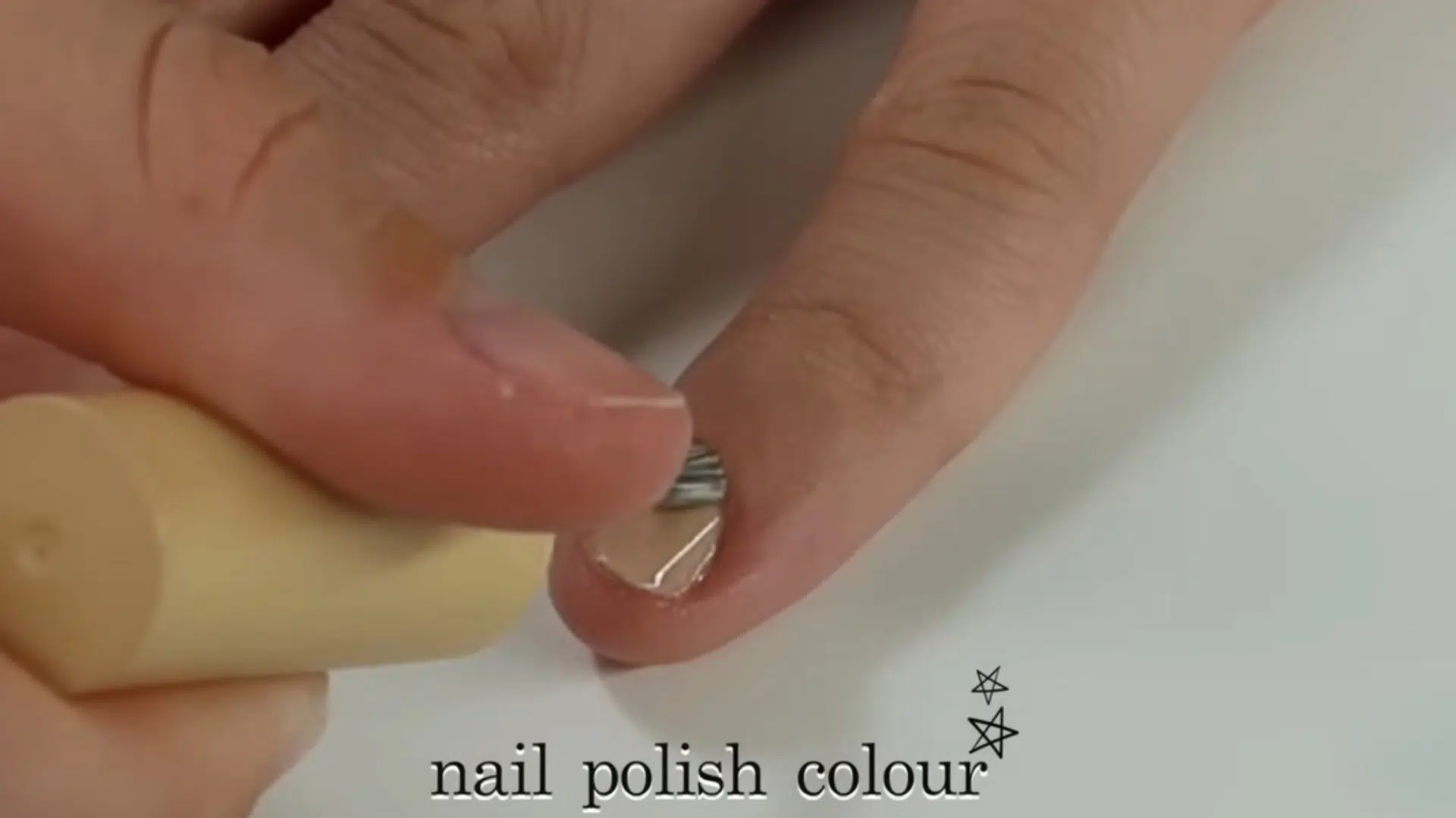 Close up of applying nail polish color on fingernail during at home manicure tutorial on YouTube
