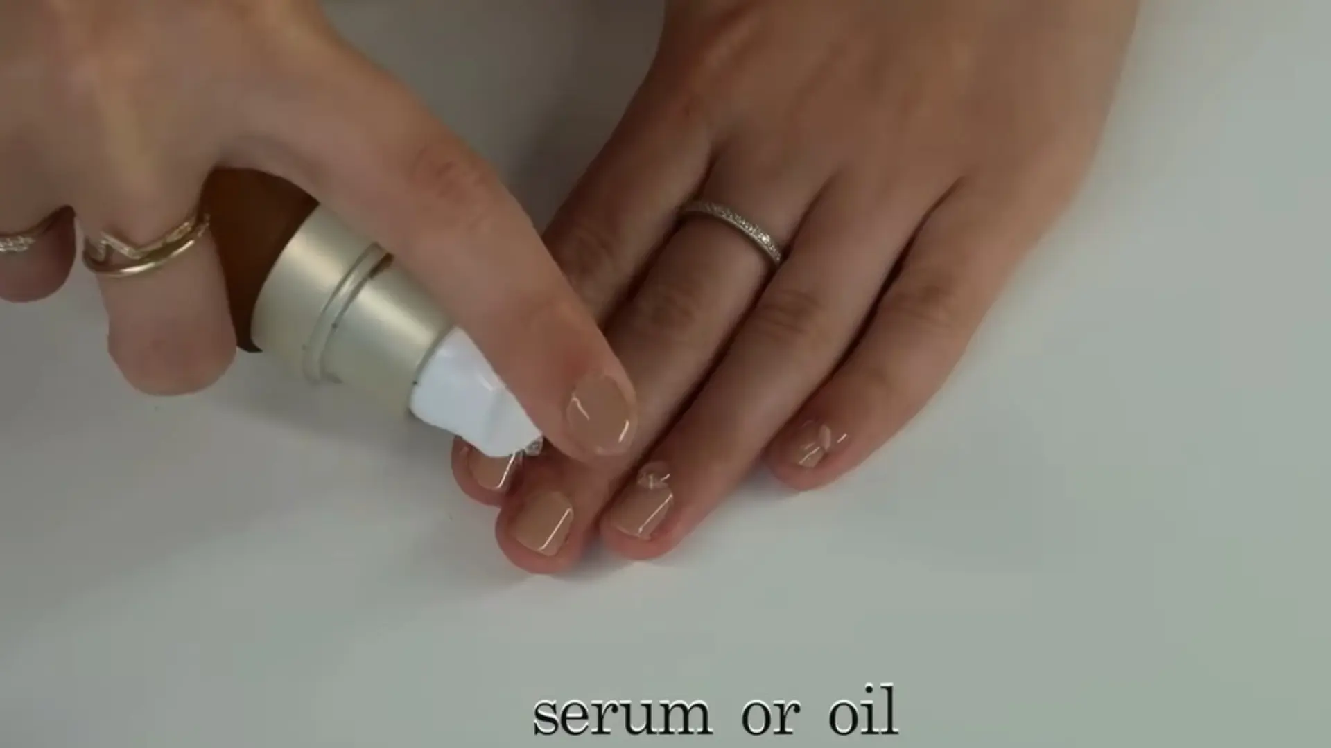 Close up of applying nail serum or oil to finished manicure, moisturizing nails on YouTube tutorial interface