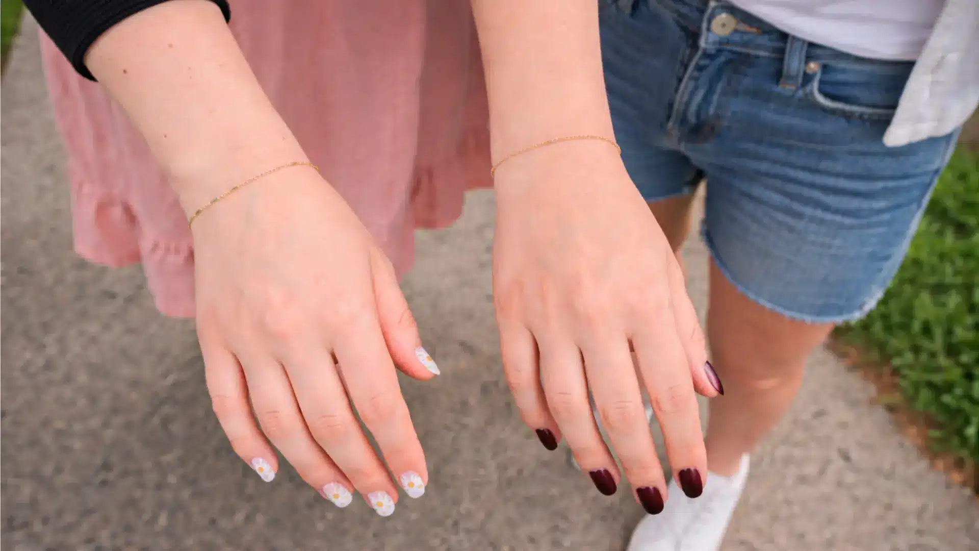 Delicate gold permanent bracelets on wrists of two friends illustrating friendship permanent jewellery