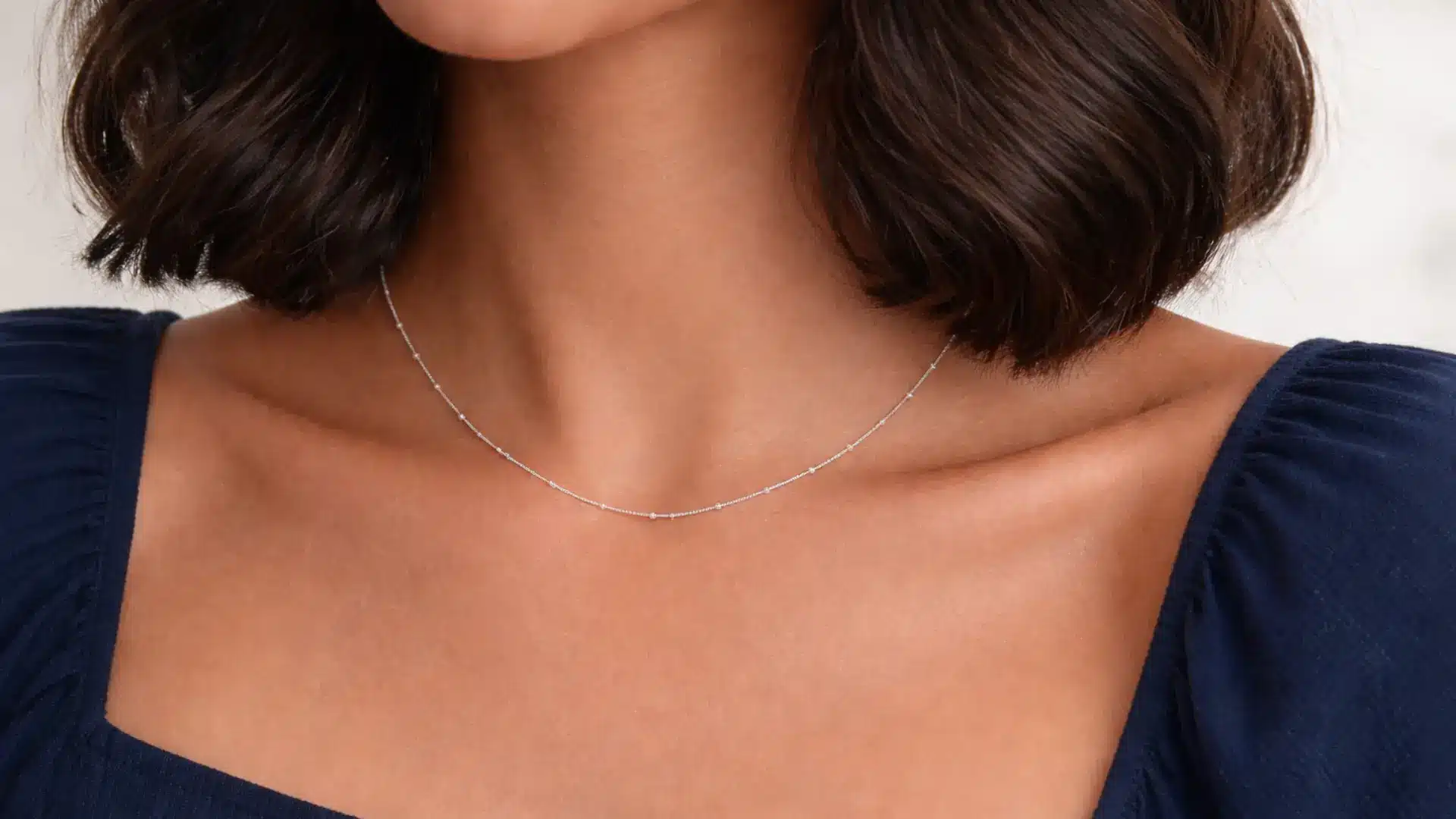 Fine chain permanent necklace on collarbone highlighting elegant permanent jewellery style on neckline