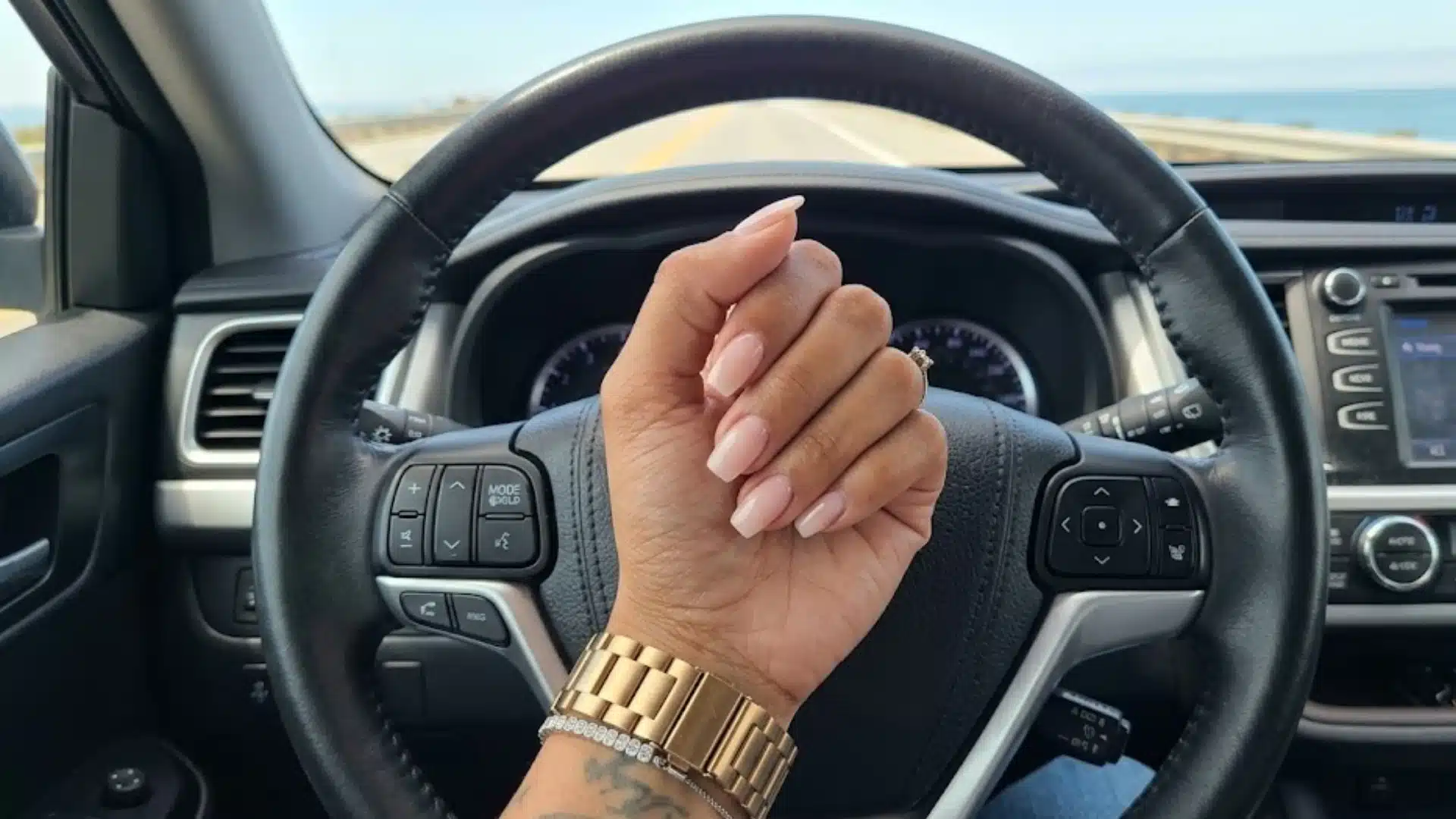 Hand with Clean Edge nails in soft nude pink, crisp square tips with glossy finish, polished minimal manicure style