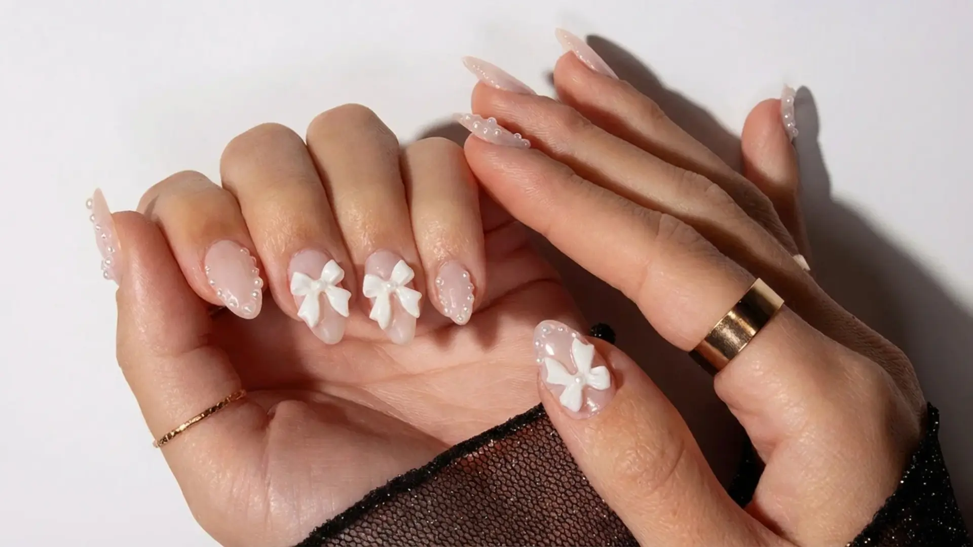 Hands with coquette bow nail art and rings for bridemaids nails ideas