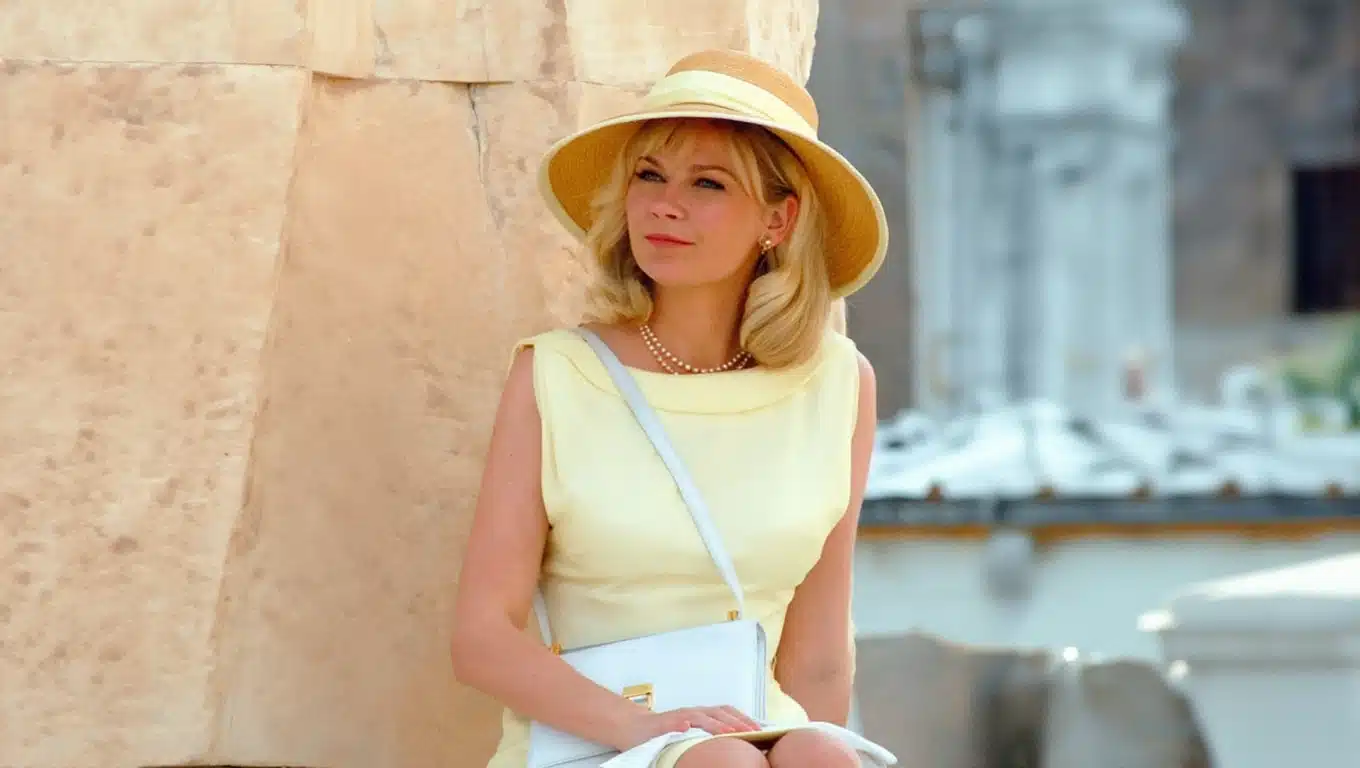 Kirsten Dunst in soft yellow dress and straw hat with light summer palette, elegant and airy styling outdoors