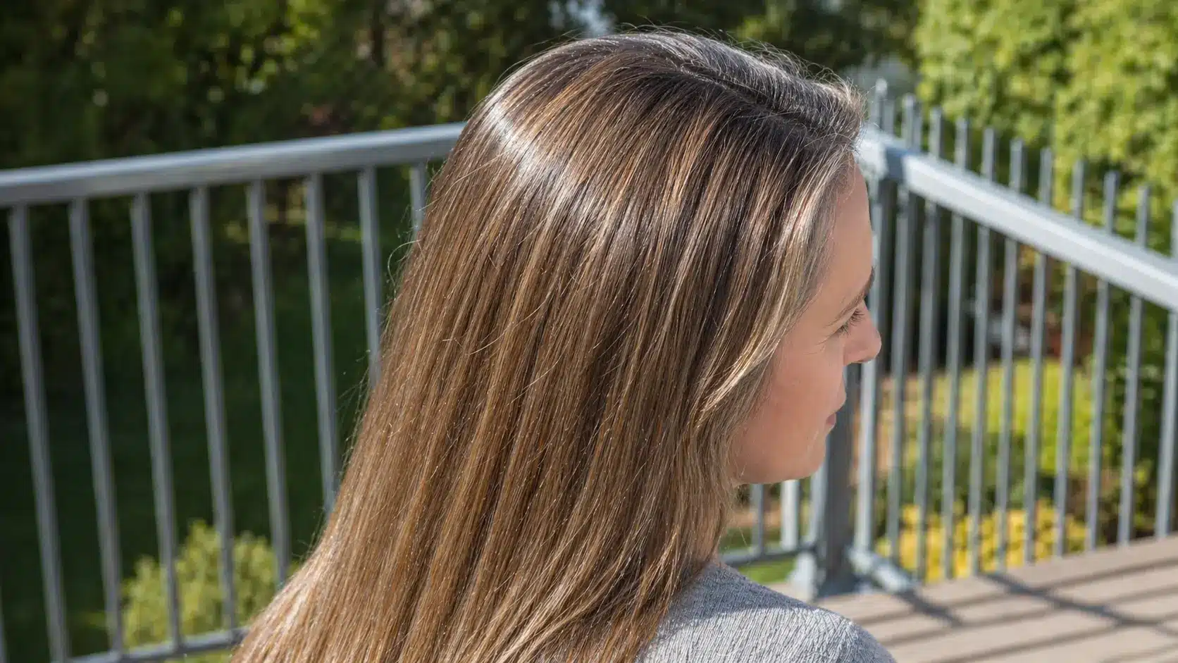 Long grey hair with babylights creating soft natural dimension and subtle brightness for a blended sun kissed look