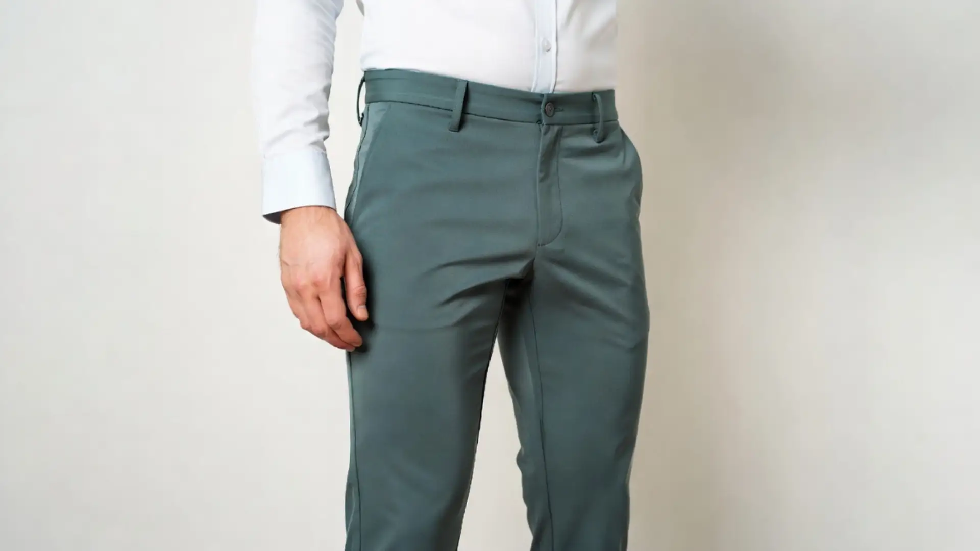 Man wearing fitted green chinos with white dress shirt, highlighting tailored fit and clean minimalist style