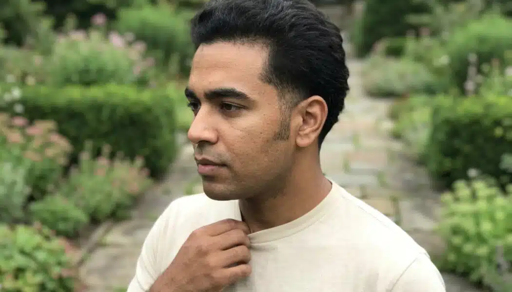 Man with a low taper haircut in a garden walkway