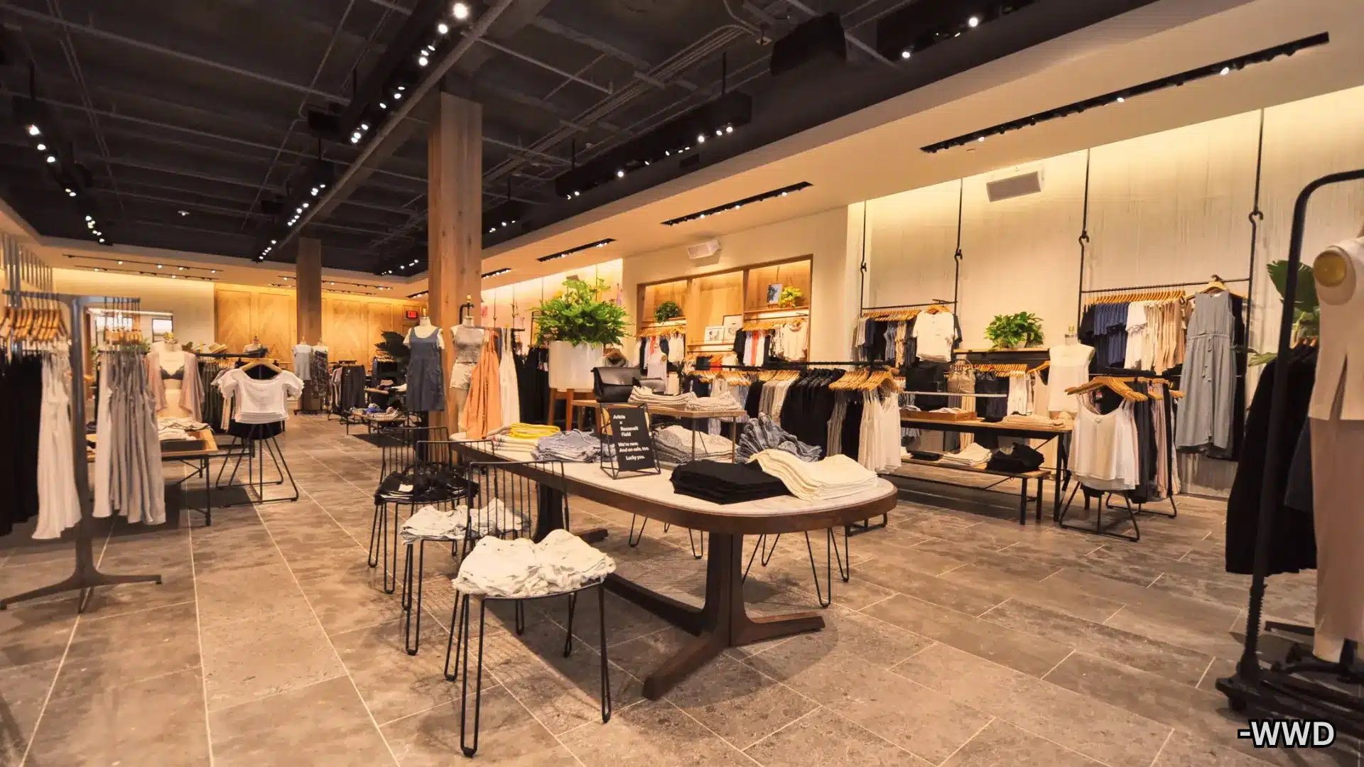 Modern Aritzia clothing store interior with neatly displayed apparel, warm lighting, and minimalist decor