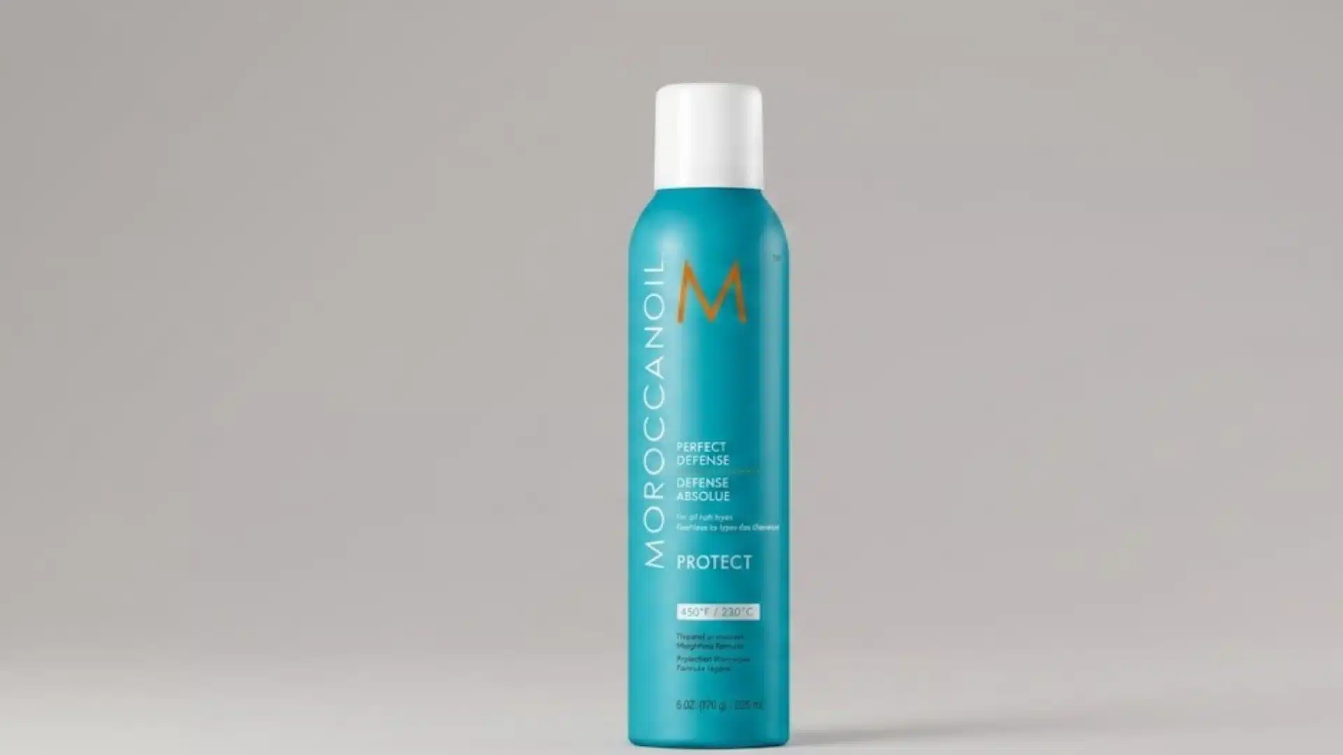 Moroccanoil Perfect Defense heat protectant spray can on a light gray background with studio lighting