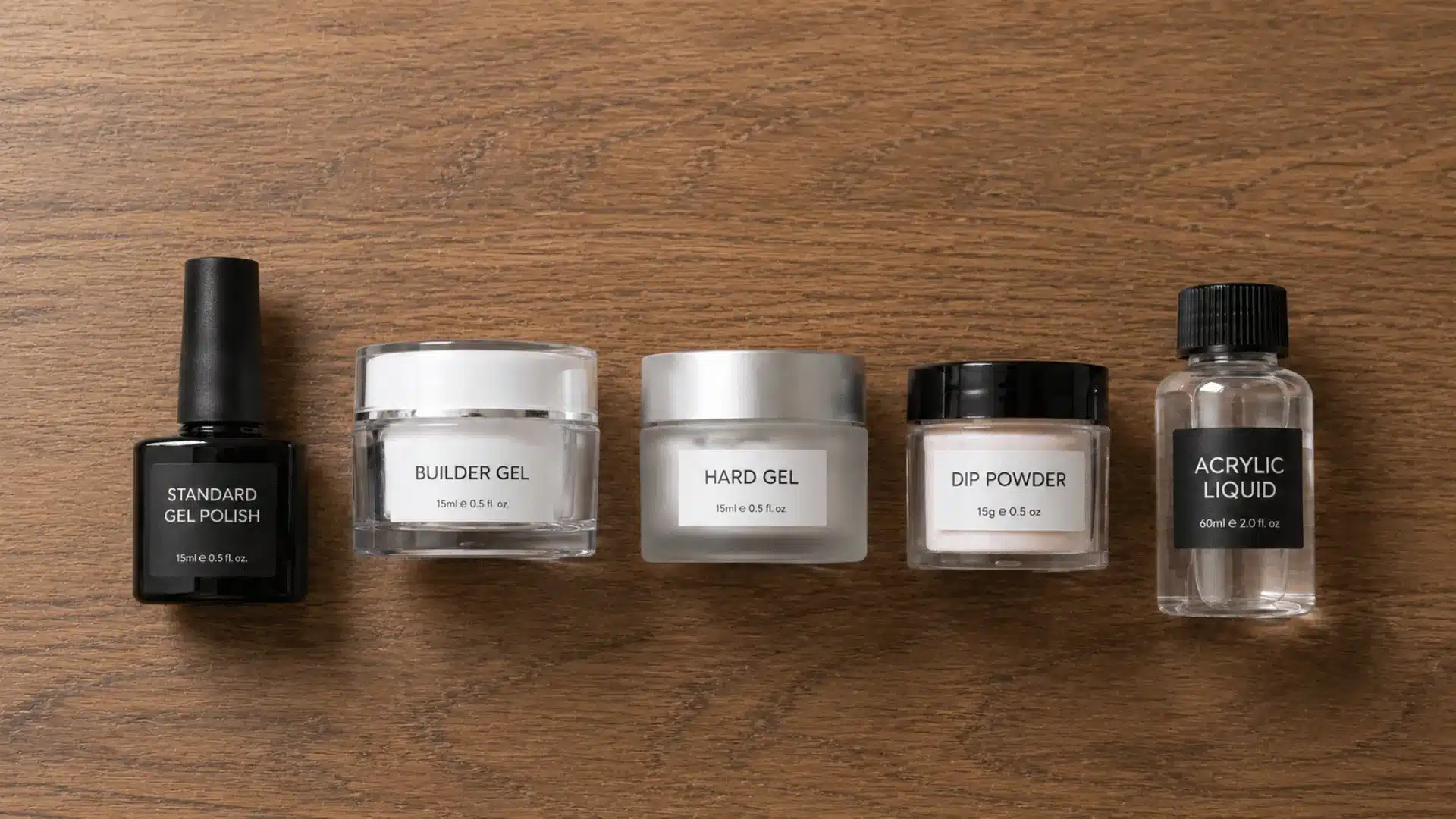 Nail gel, dip powder, and acrylic liquid containers arranged on a brown wooden table