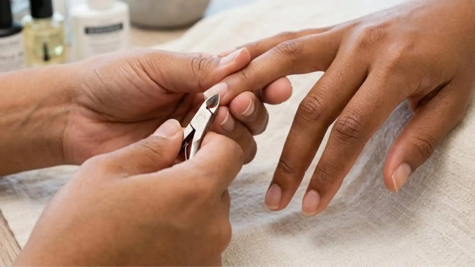 Nail technician trimming a hangnail during a manicure treatment