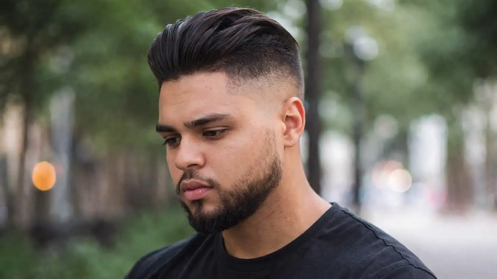 Side profile of man with high fade slick back hairstyle for round face showing volume on top and clean faded sides