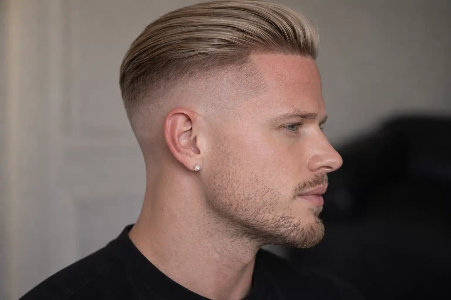 Side profile of man with high fade slick back hairstyle for straight hair showing sleek top and clean blended faded sides cut
