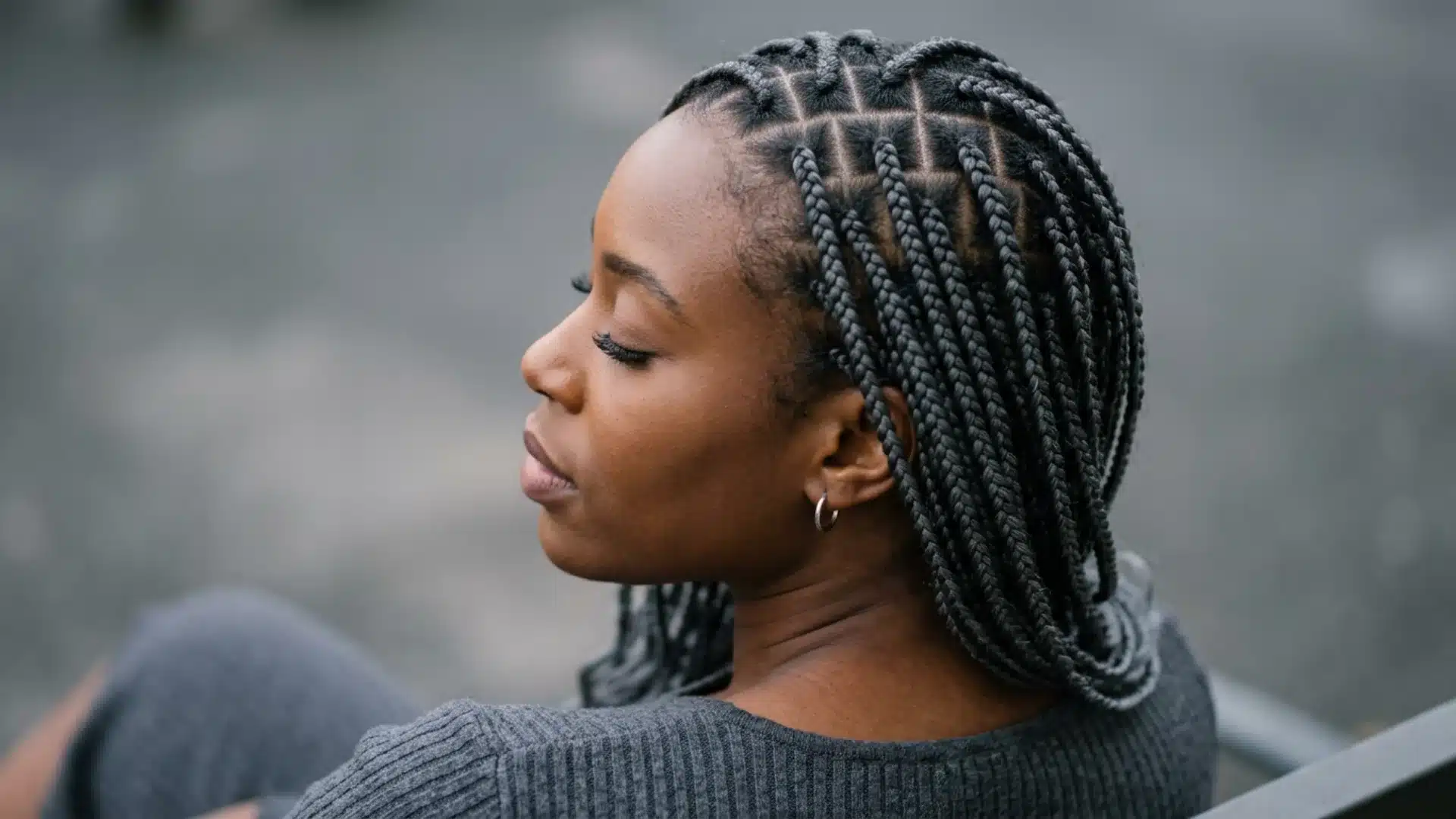 Side view of knotless braids showing flat smooth roots blending into natural scalp