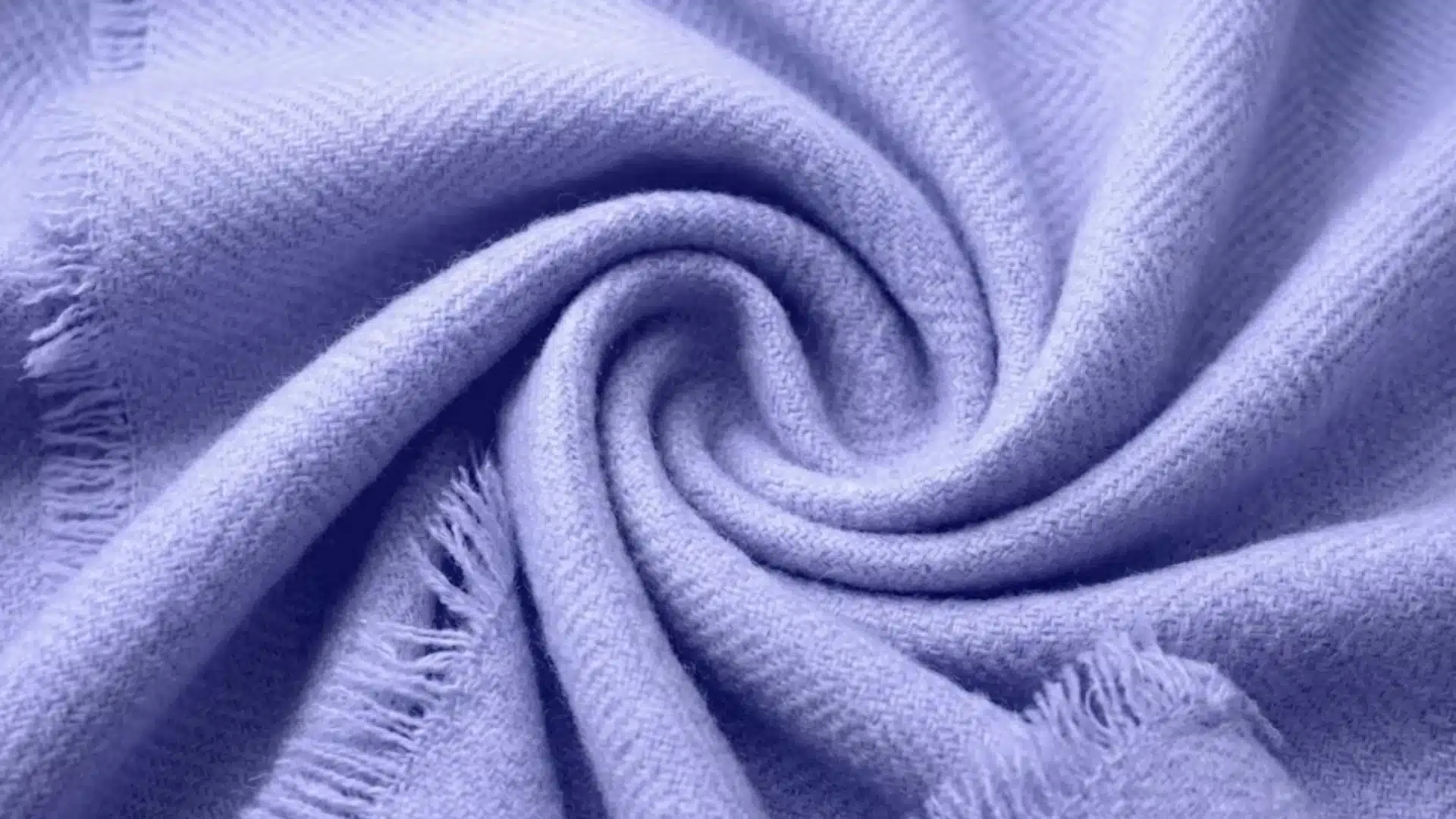 Soft lavender acrylic fabric twisted in a spiral with visible woven texture and frayed edges