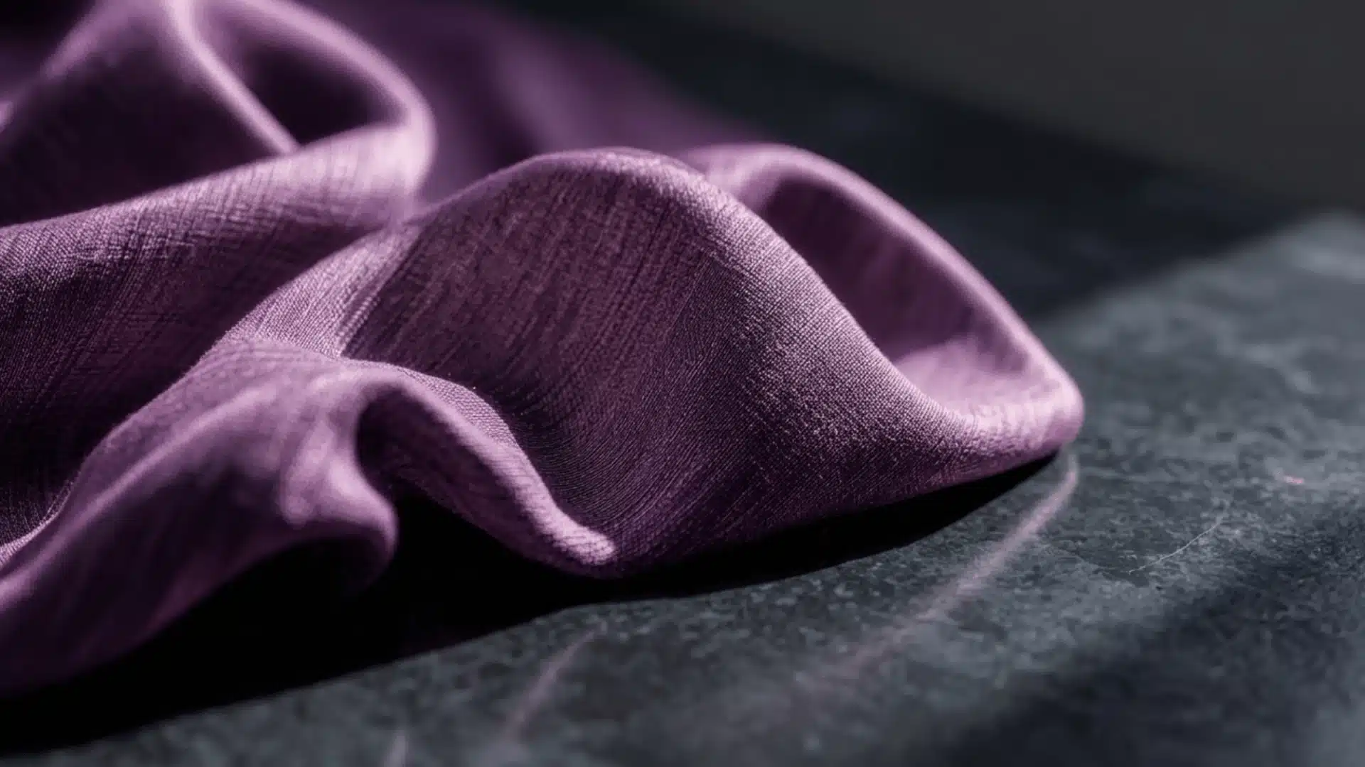Soft purple modal fabric draped on a dark surface, highlighting its smooth texture and gentle folds