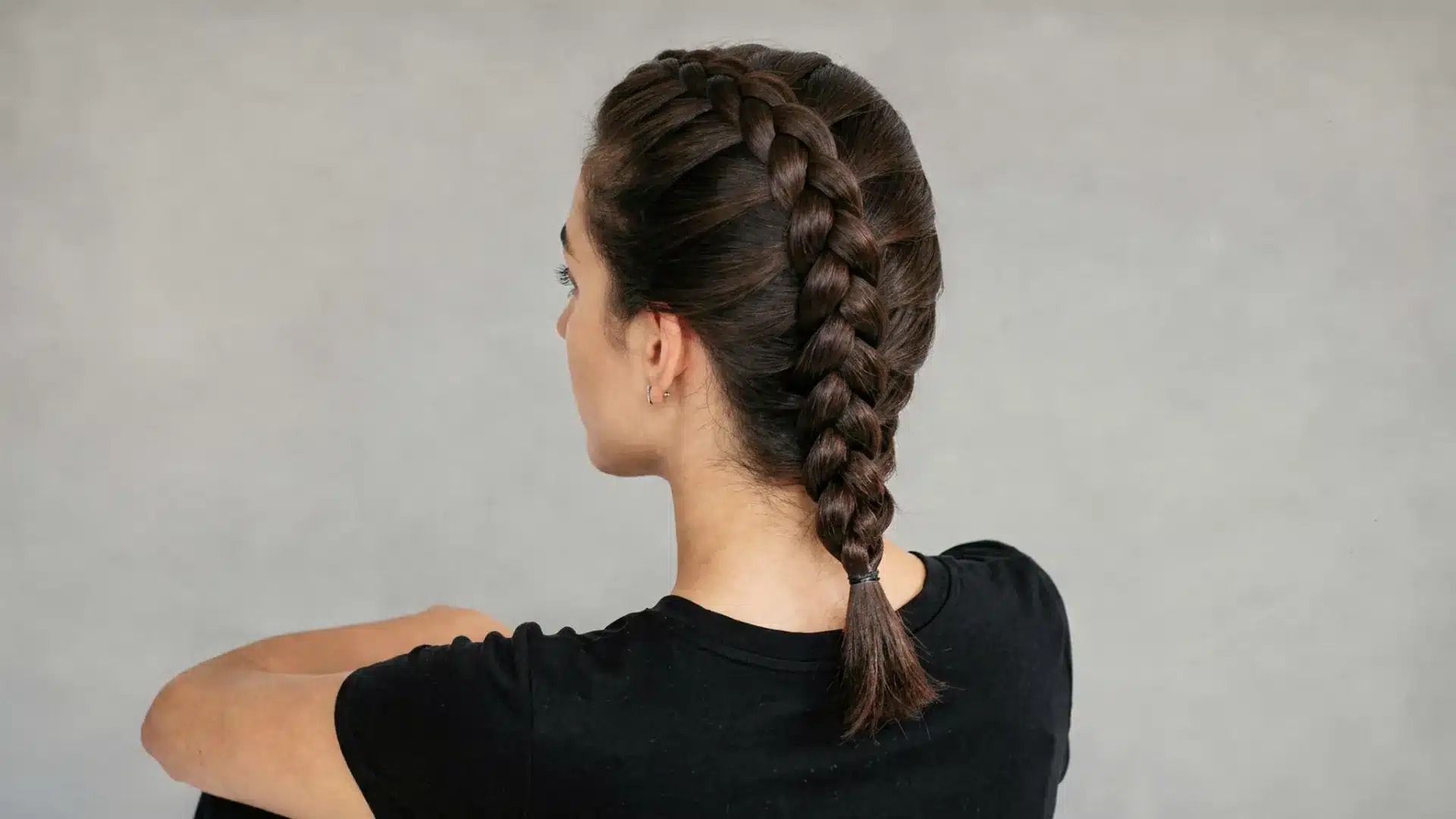 Three-quarter back view of a Dutch braid showing the raised three-dimensional ridge on dark hair