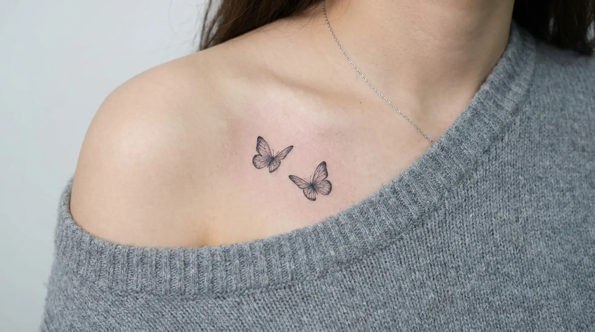 Two small butterfly tattoos on collarbone symbolizing freedom transformation and personal change