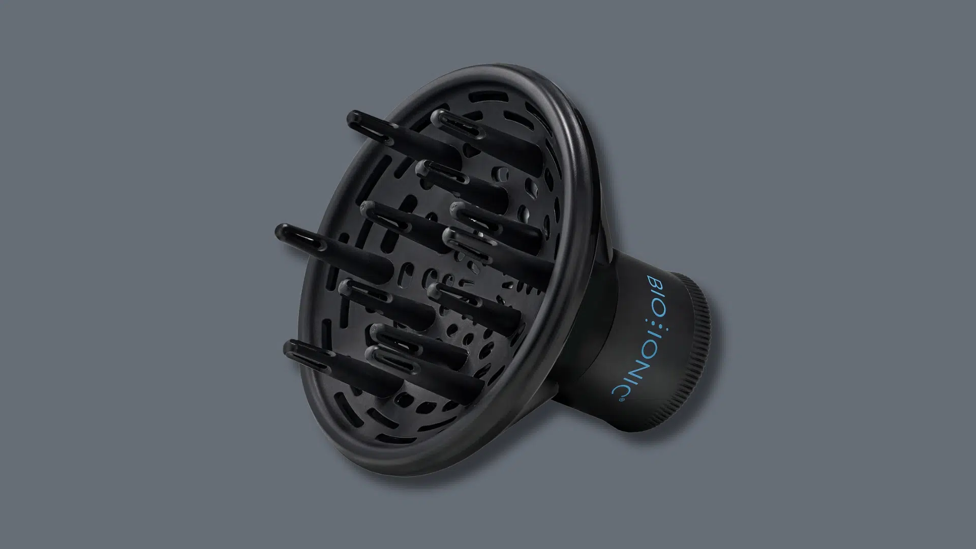 Black Bio Ionic hair dryer diffuser attachment with long prongs, isolated on a dark gray background