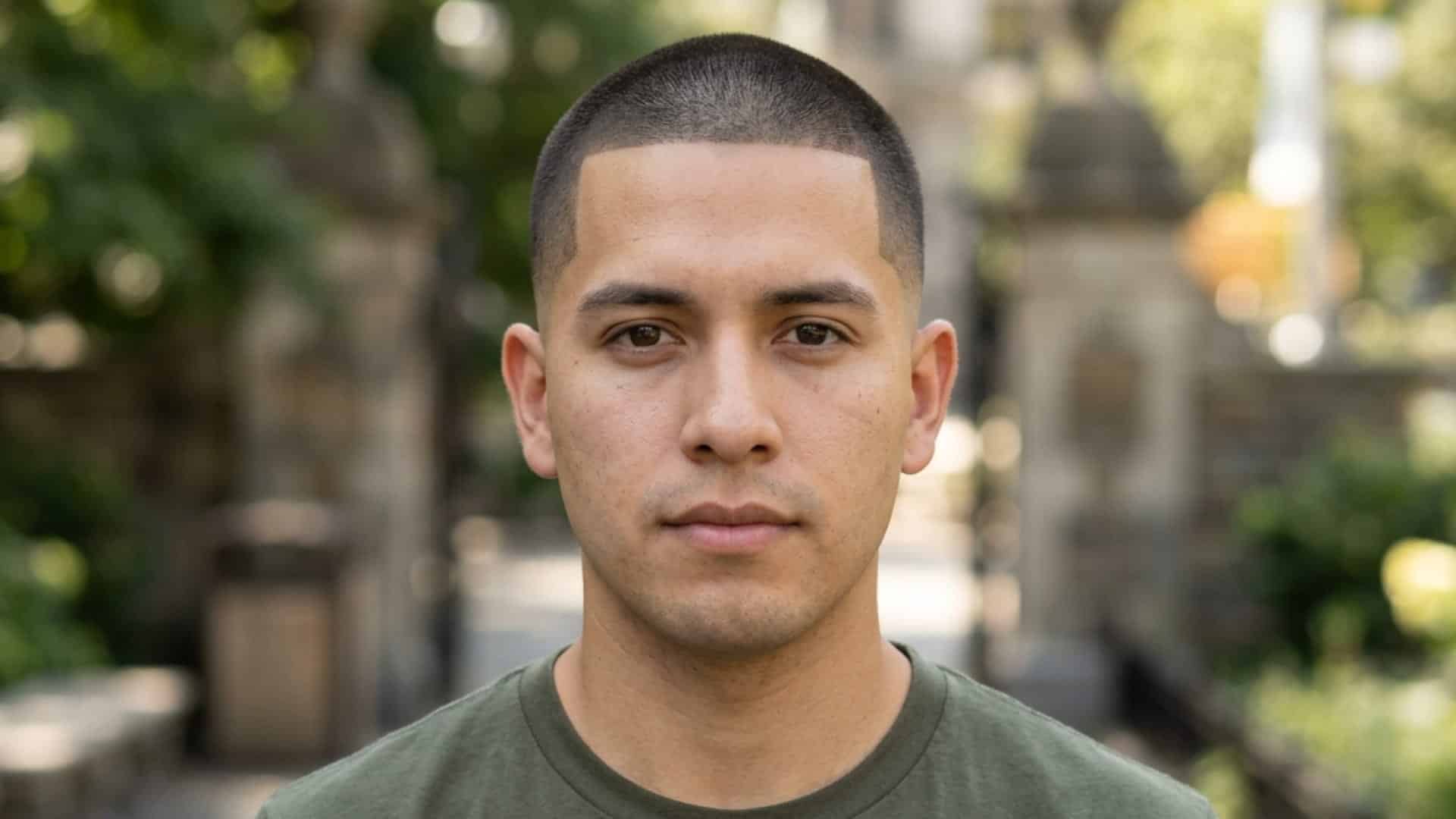 Man with a clean military cut and a sharp hairline outdoors