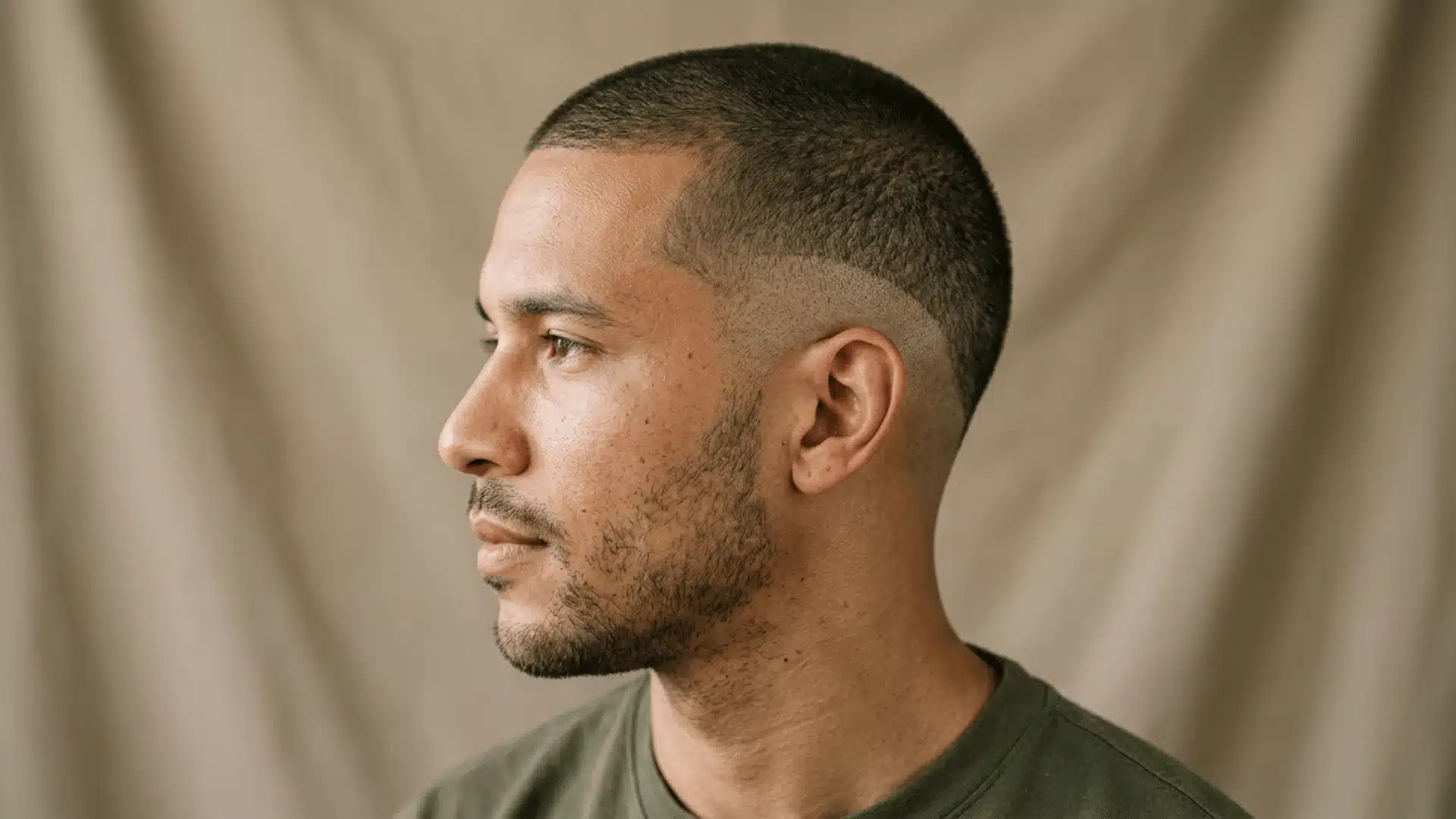 Man with a drop fade buzz cut showing a curved fade behind the ear