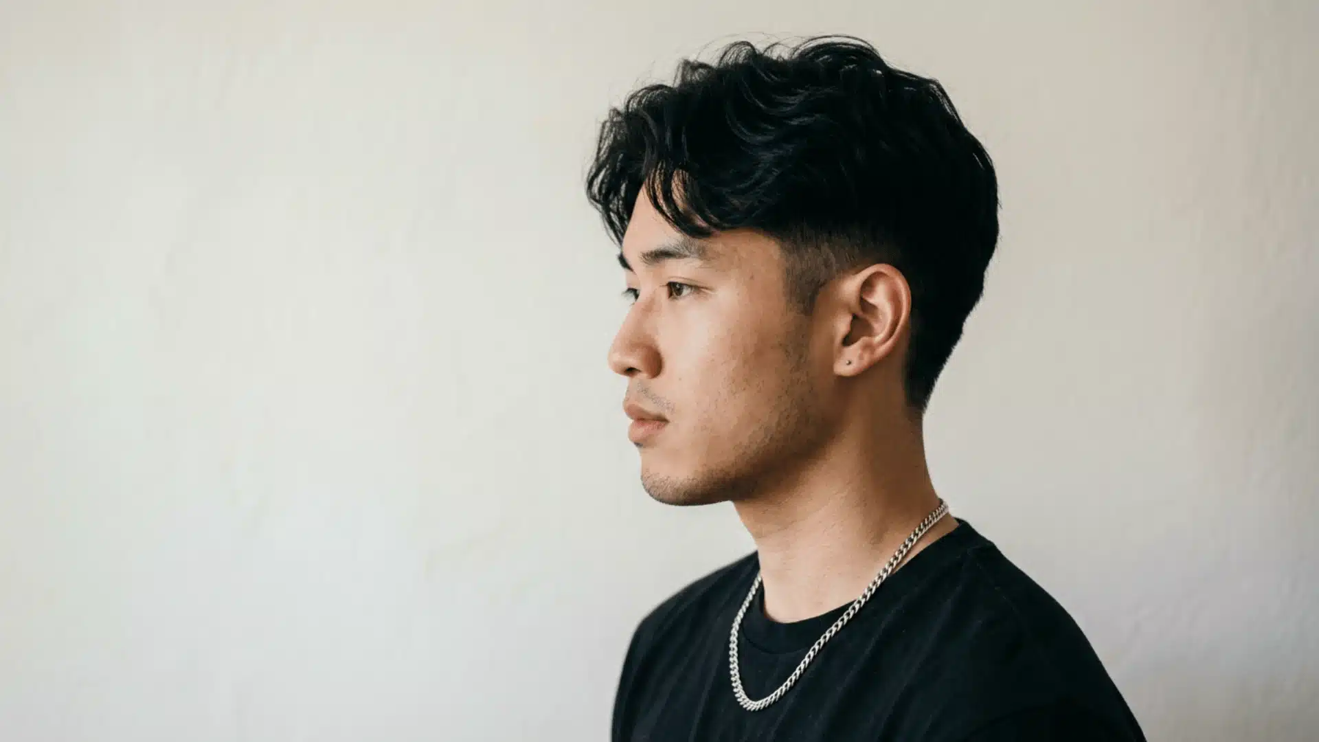 Man with comma hair perm showing curved fringe bending inward near the forehead