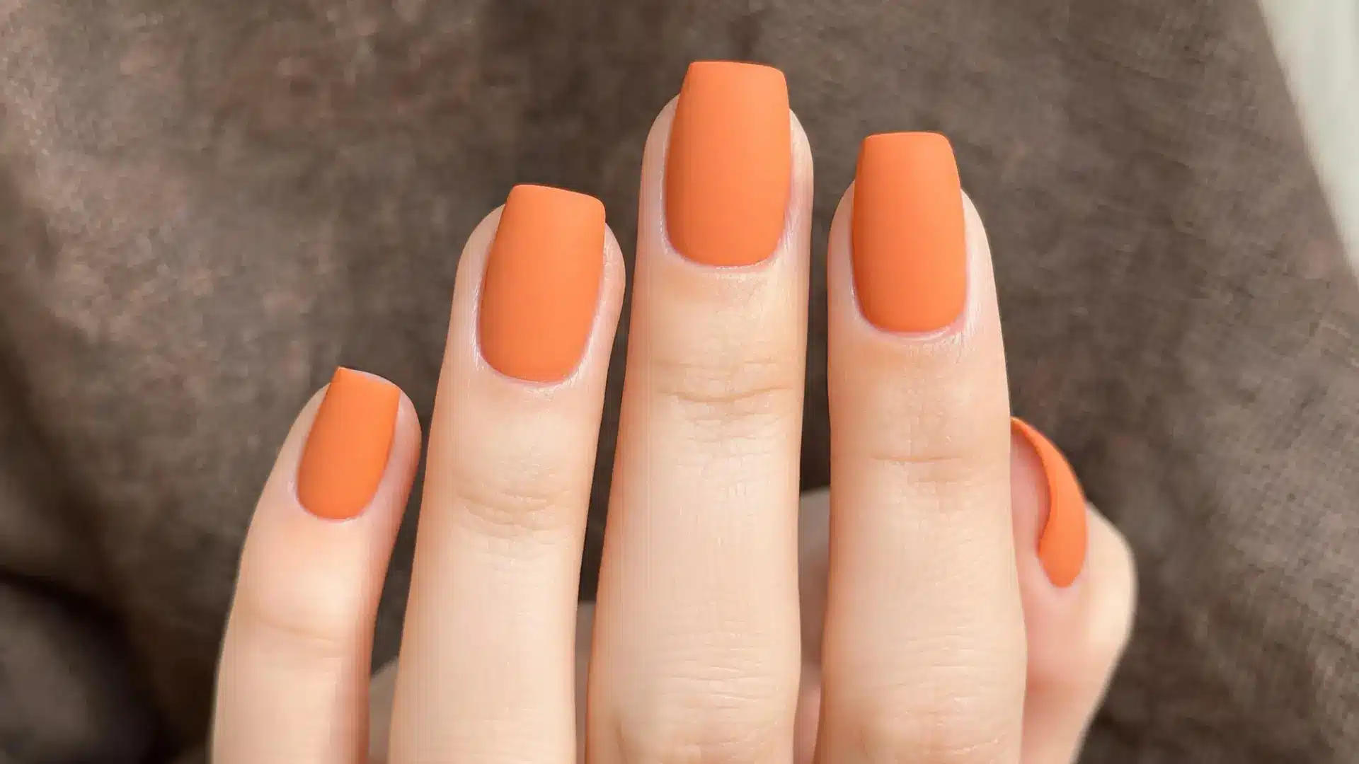 Matte orange square nails close up